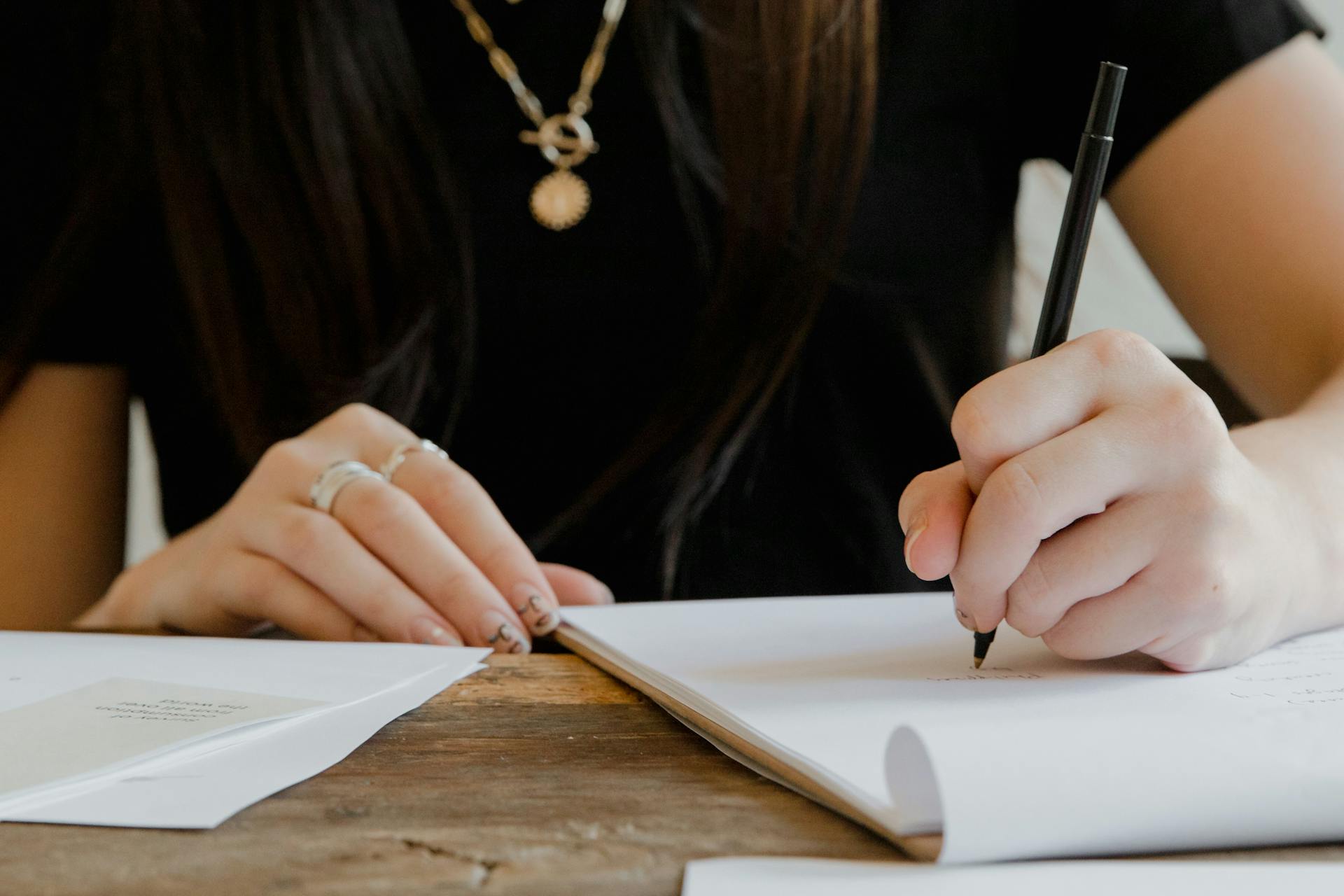 Una mujer escribiendo en un papel | Fuente: Pexels