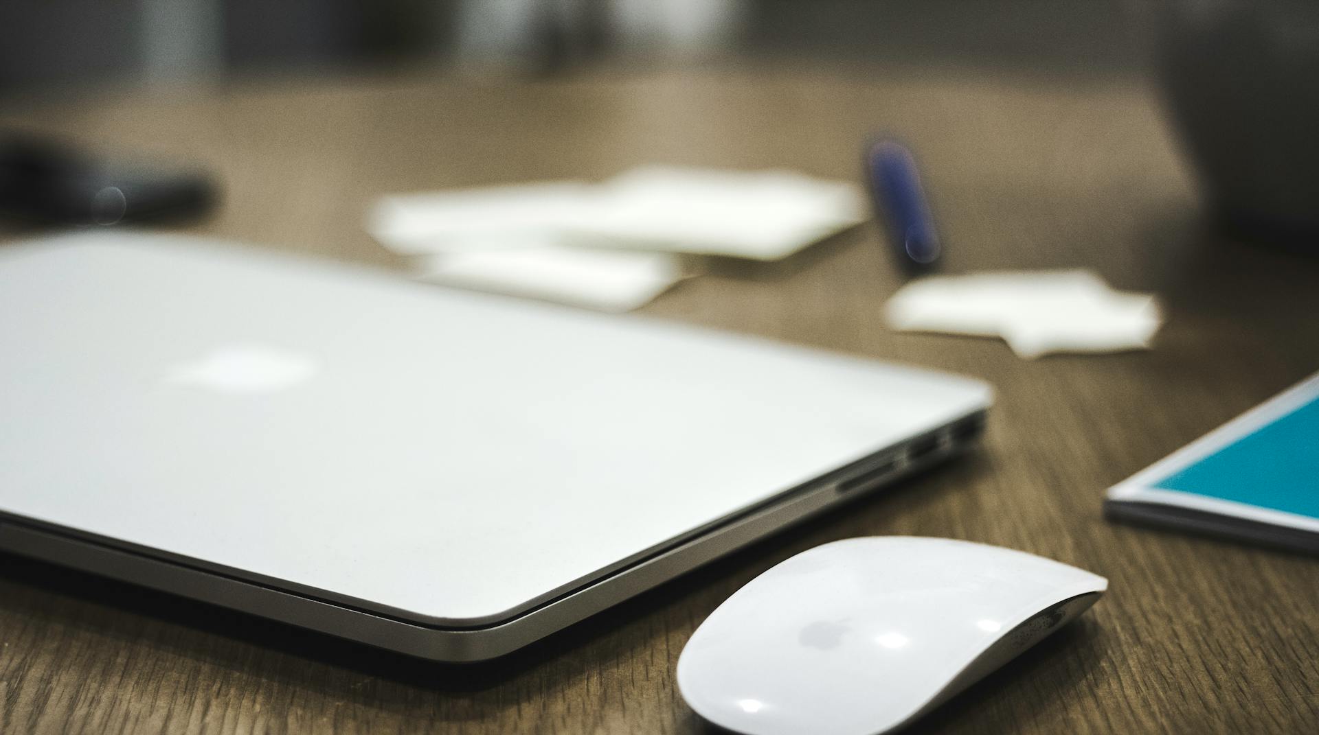 Un portátil y un ratón inalámbrico sobre la mesa | Fuente: Pexels