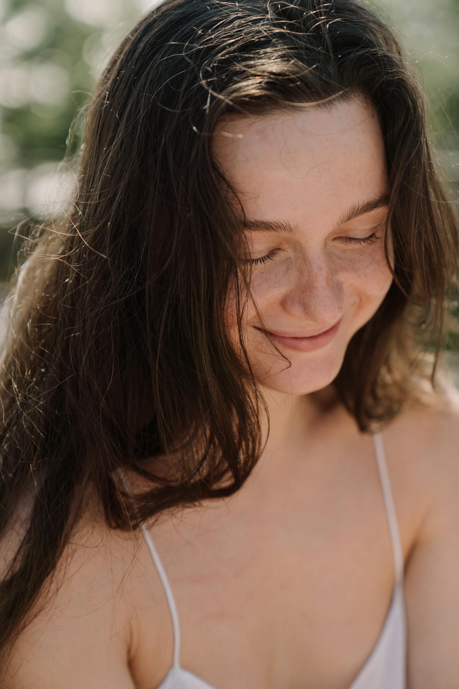 Una mujer sonriendo tímidamente | Fuente: Pexels