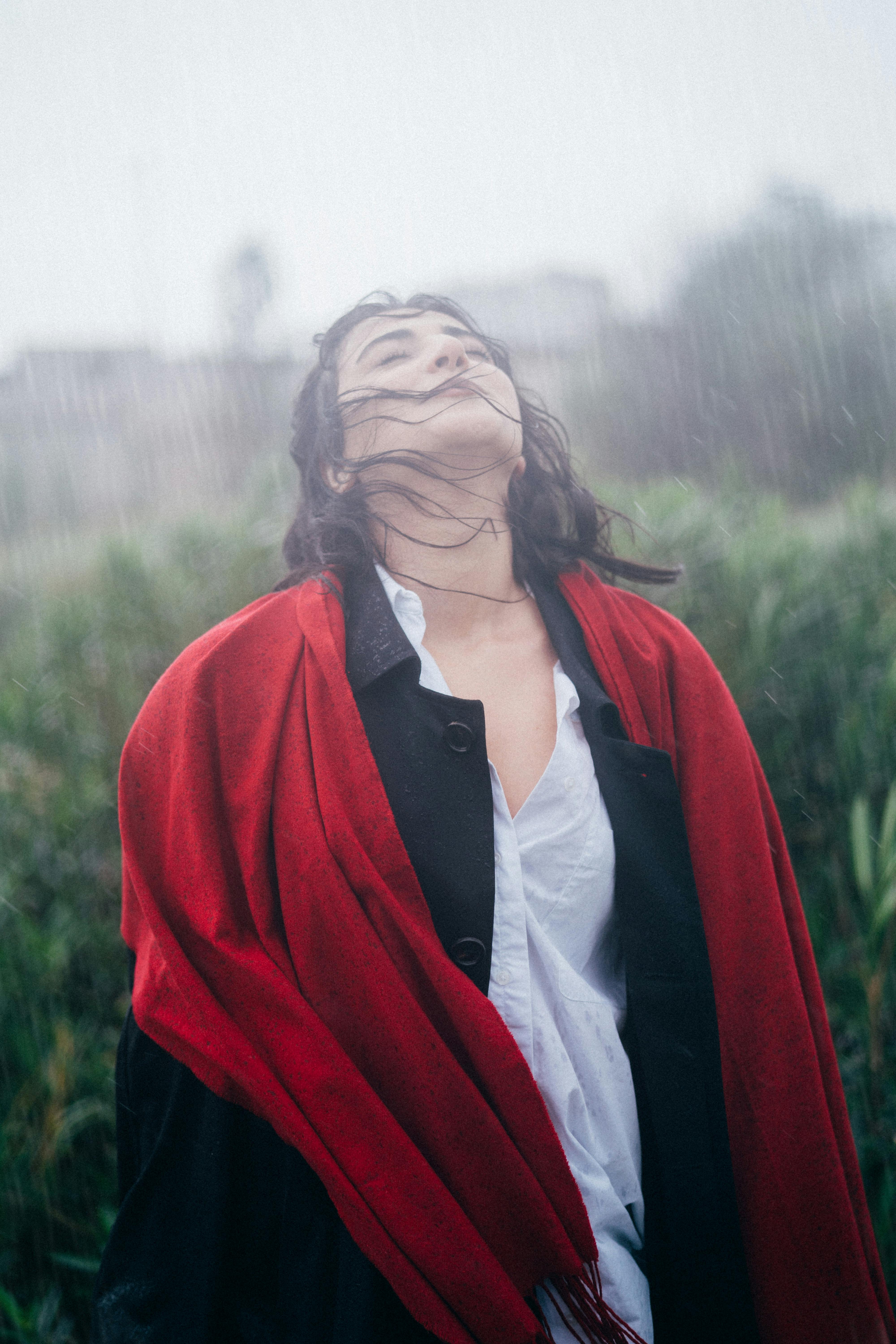 Mujer de pie con los ojos cerrados bajo la lluvia | Fuente: Pexels