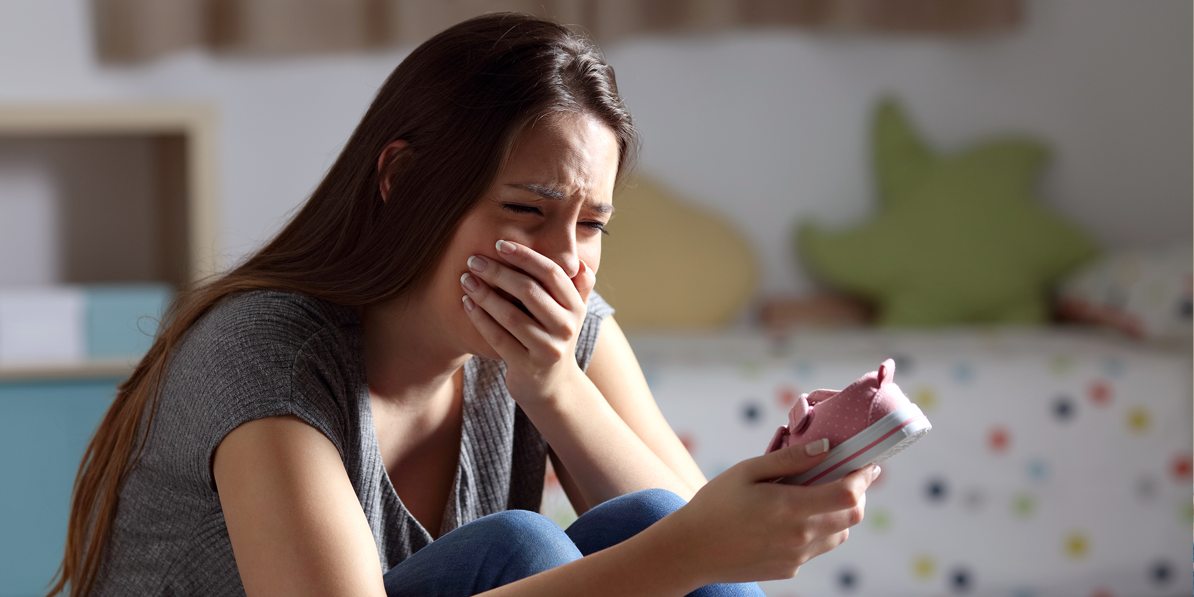 Mujer llorando con un zapatito en la mano | Fuente: Shutterstock