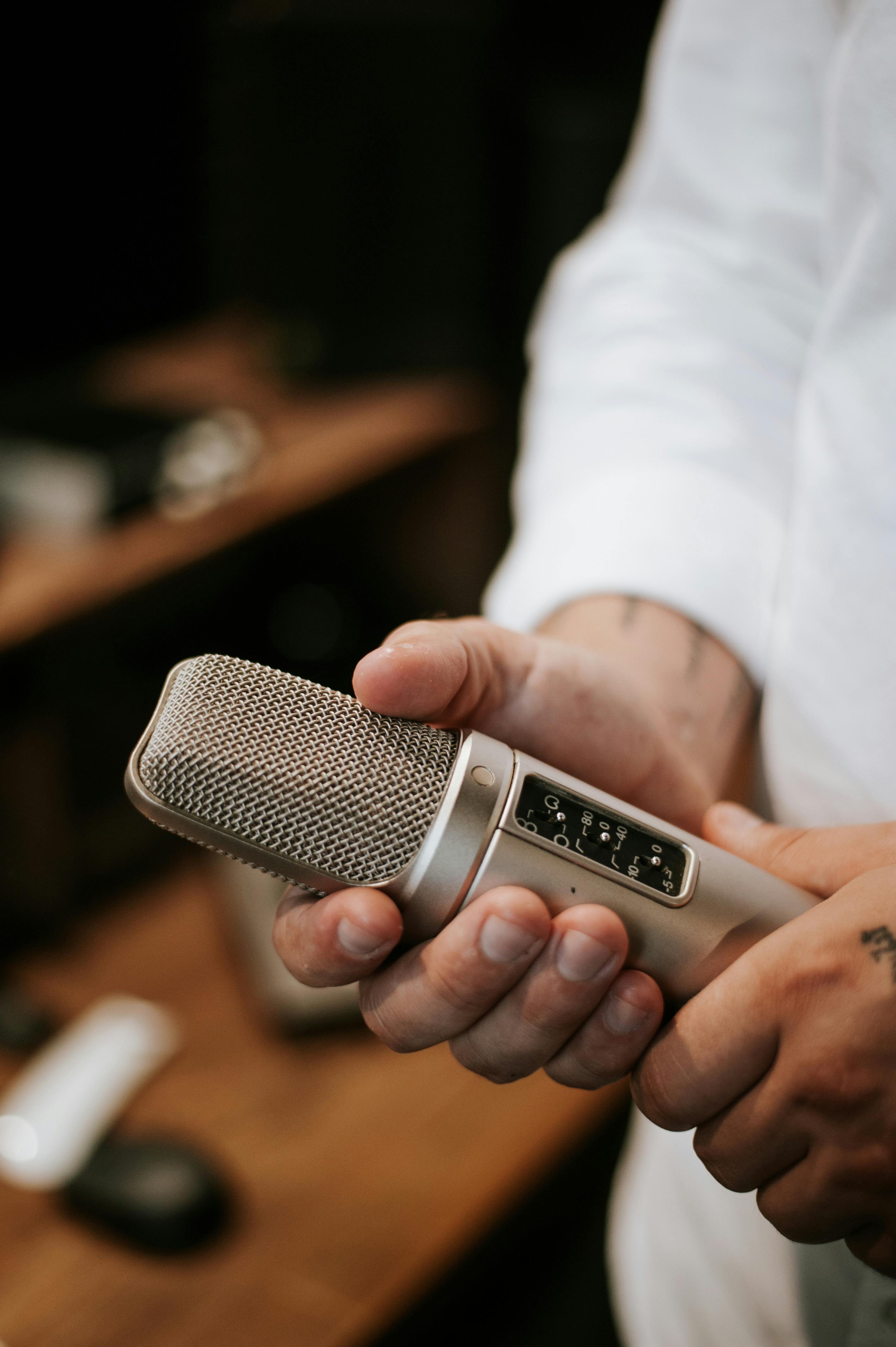 Un hombre sujetando un micrófono | Fuente: Pexels