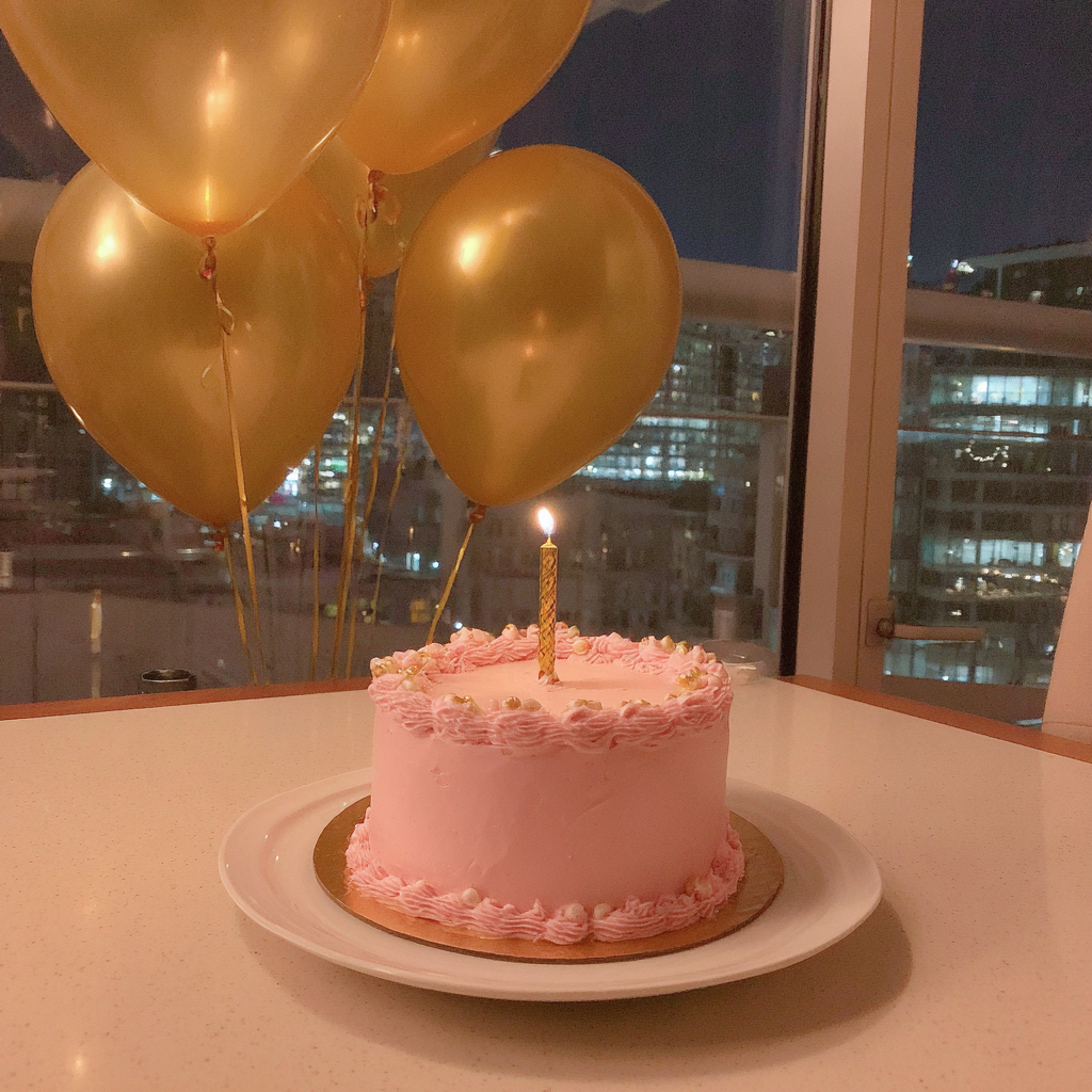 Pastel de cumpleaños rosa y globos dorados | Fuente: Midjourney