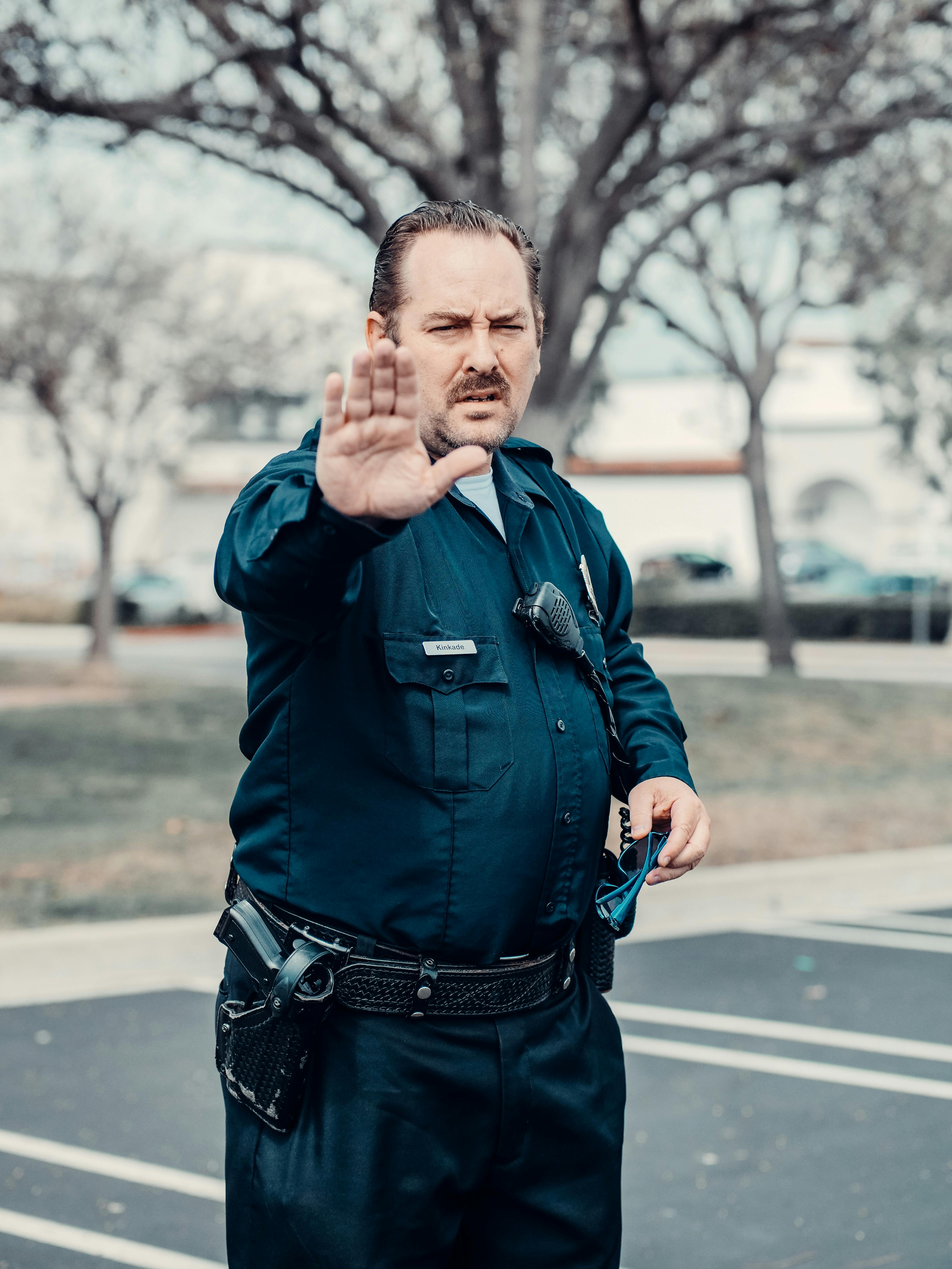 Un policía con la mano levantada | Fuente: Pexels