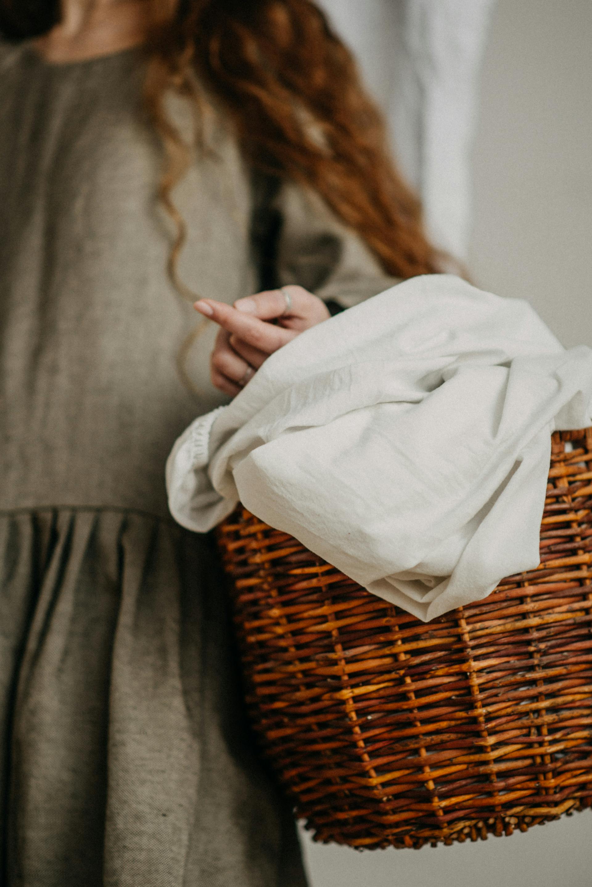 Una mujer con un cesto de la ropa sucia | Fuente: Pexels