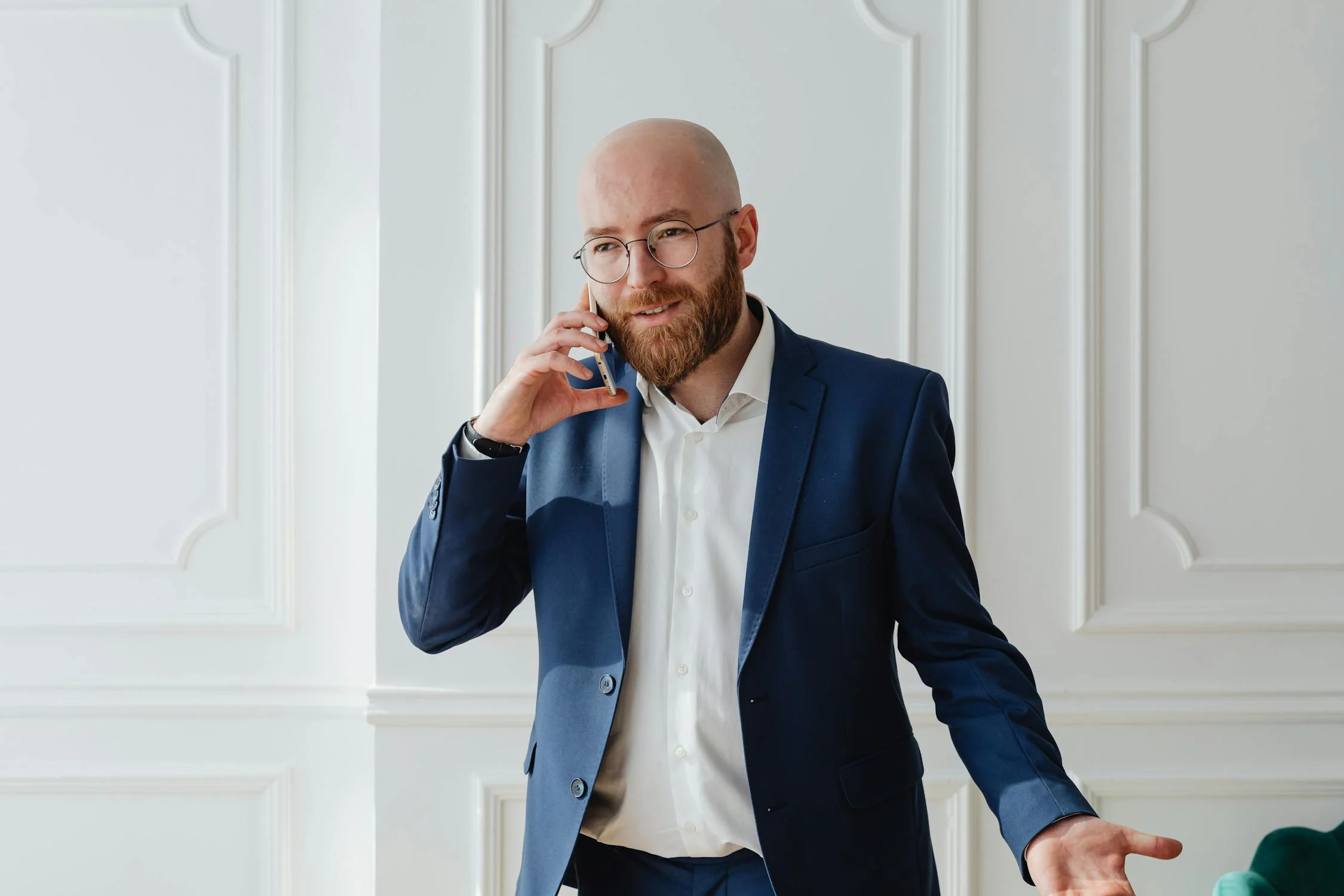 Un hombre sonriente vestido de traje hablando por teléfono | Fuente: Pexels