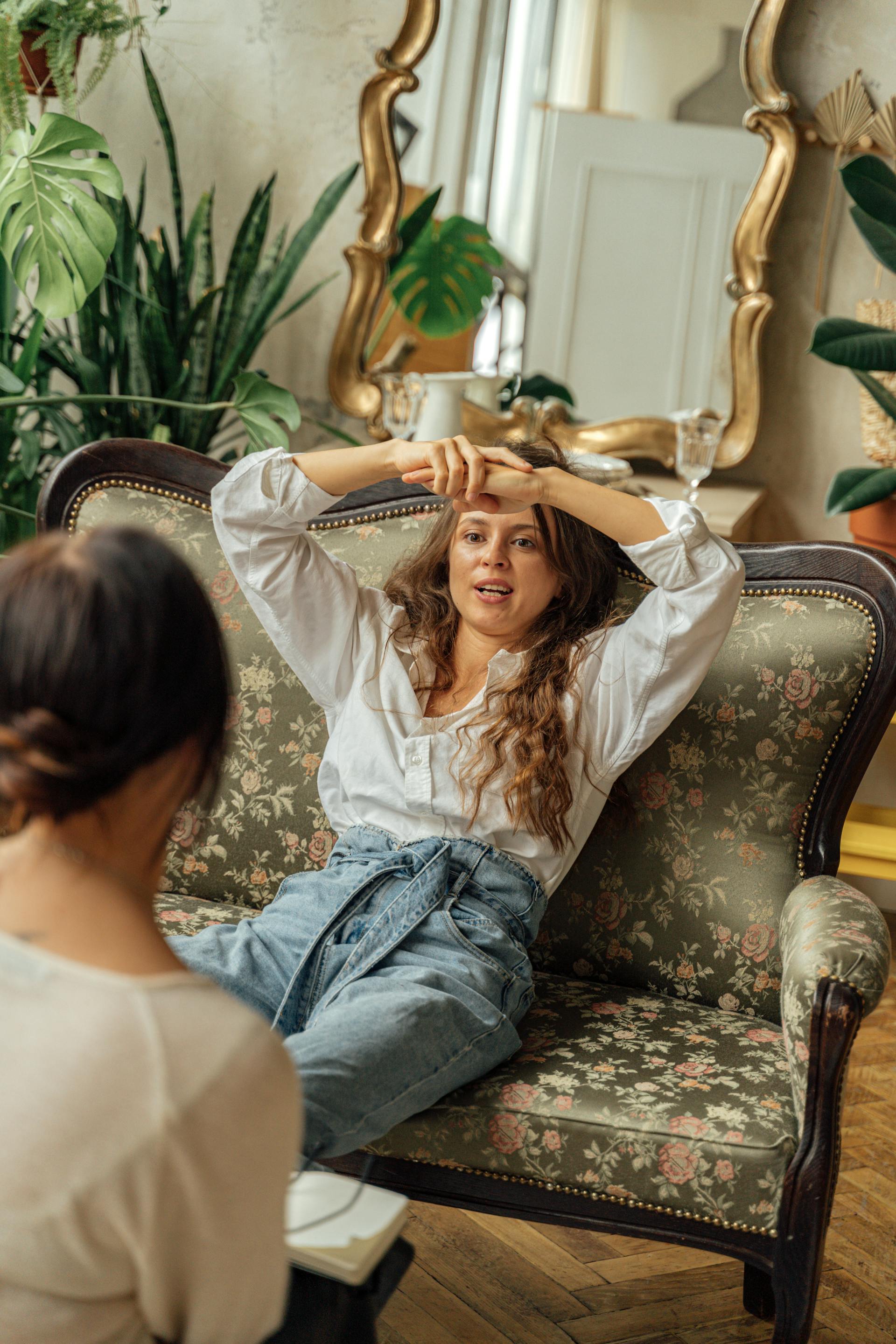 Una mujer sentada en un sofá y hablando con su amiga | Fuente: Pexels