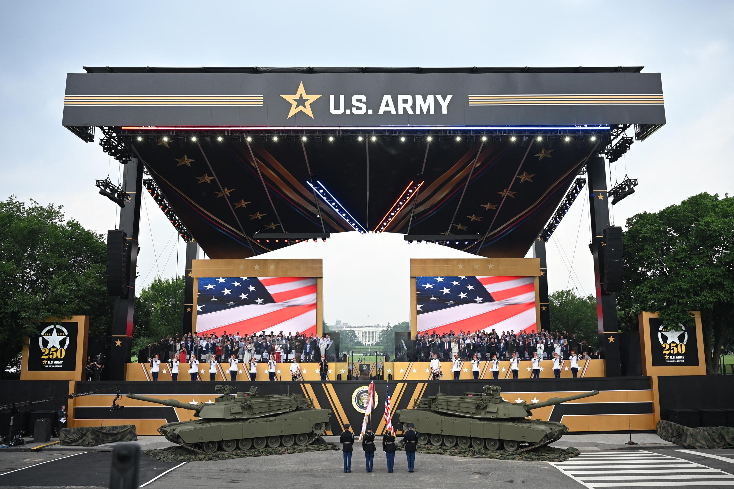 Donald y Melania Trump junto con otras personas se reúnen en el escenario para ver el desfile del 250° aniversario del Ejército de EE.UU. el 14 de junio de 2025 | Fuente: Getty Images