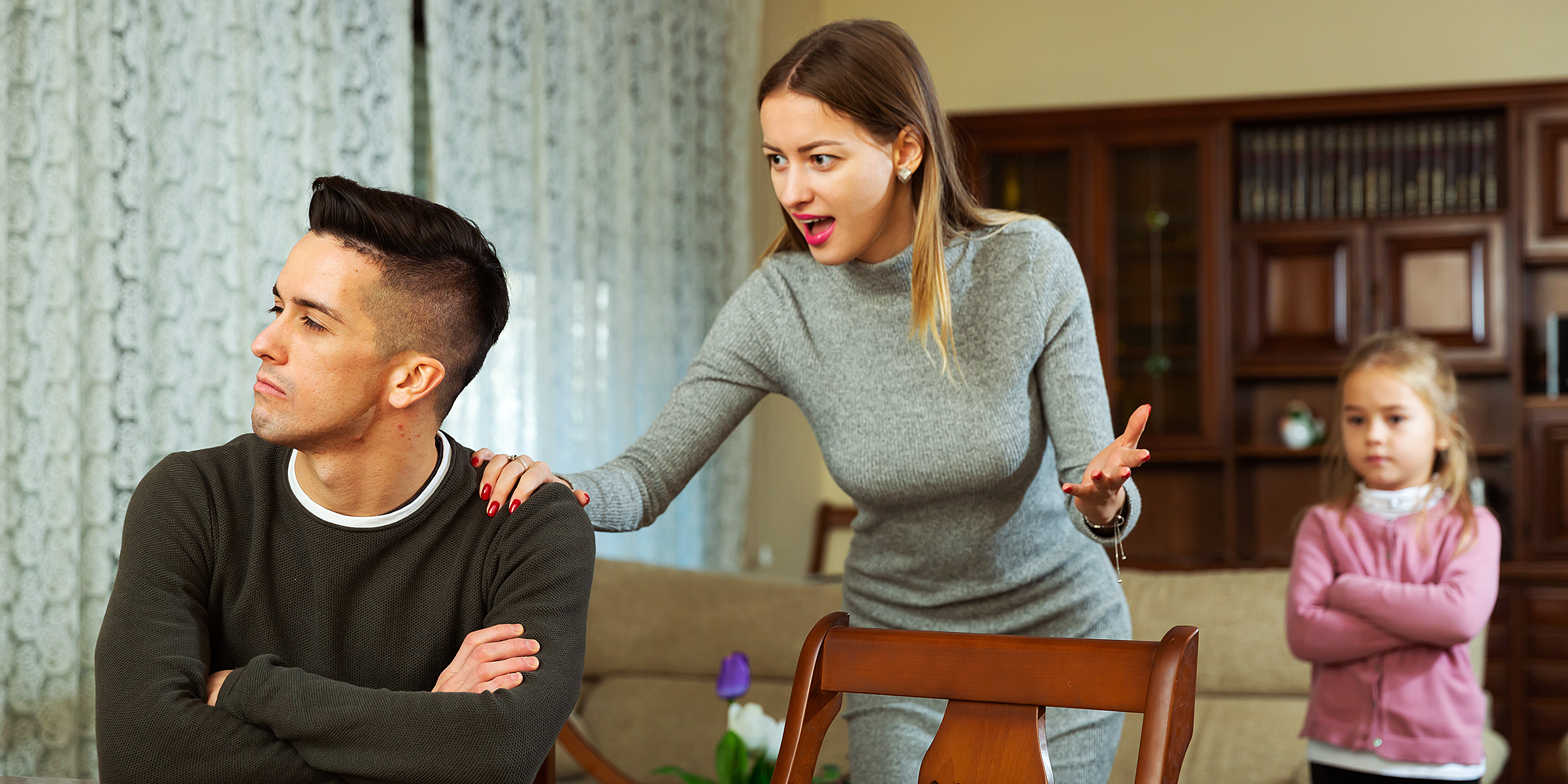 Momento tenso entre una pareja mientras su hija mira | Fuente: Shutterstock