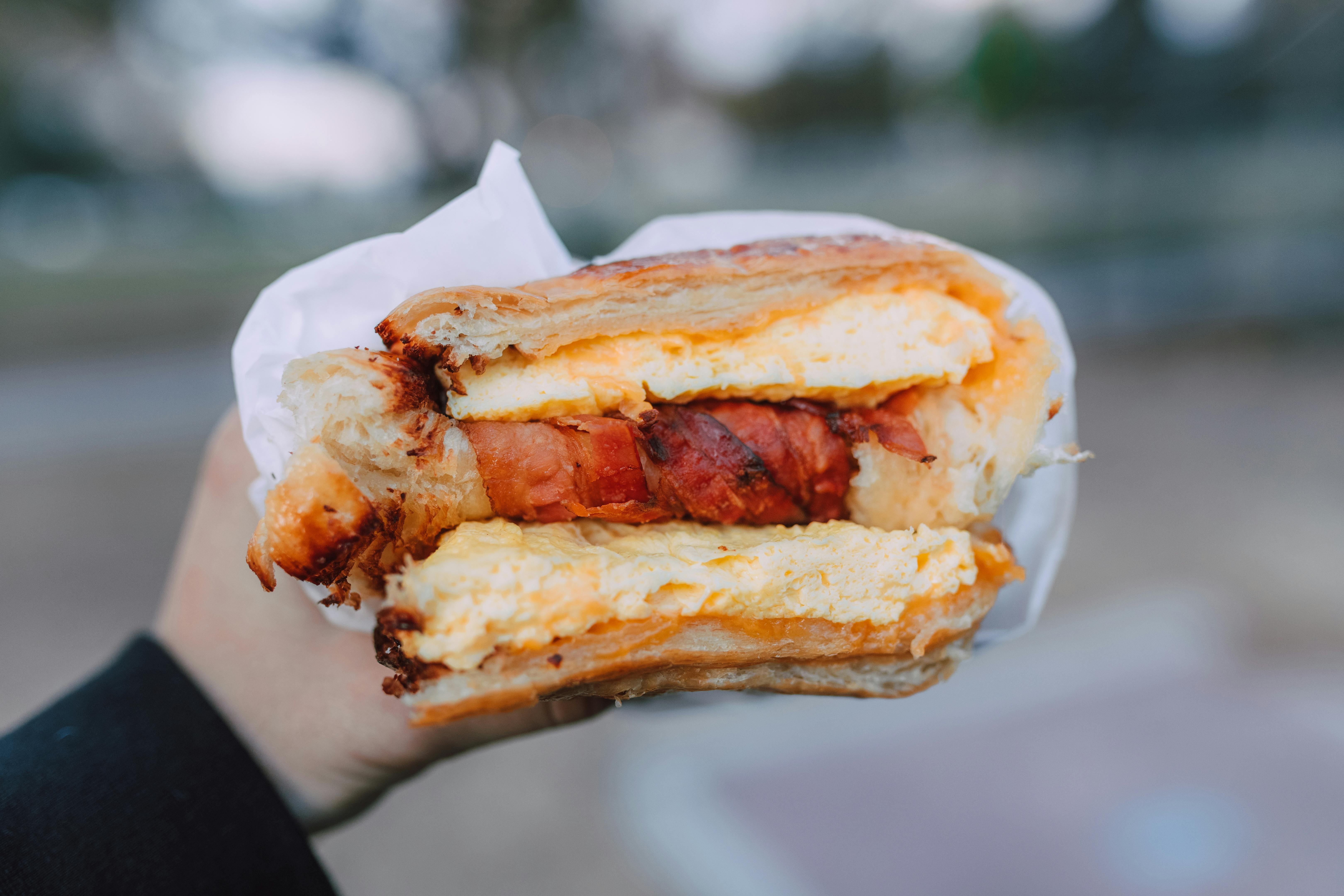 Una persona con un bocadillo en la mano | Fuente: Pexels