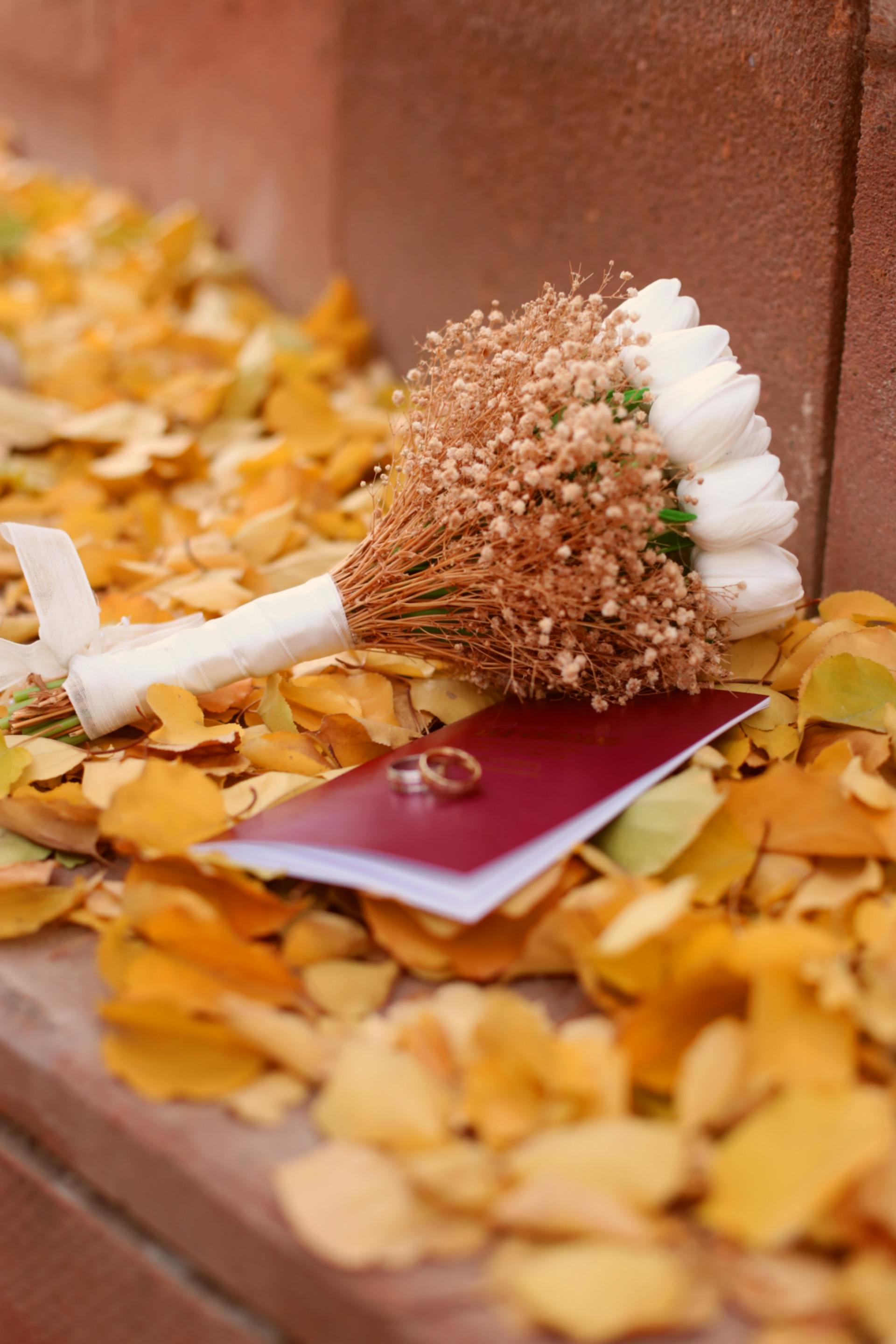 Un ramo de novia con anillos sobre hojas otoñales | Fuente: Pexels