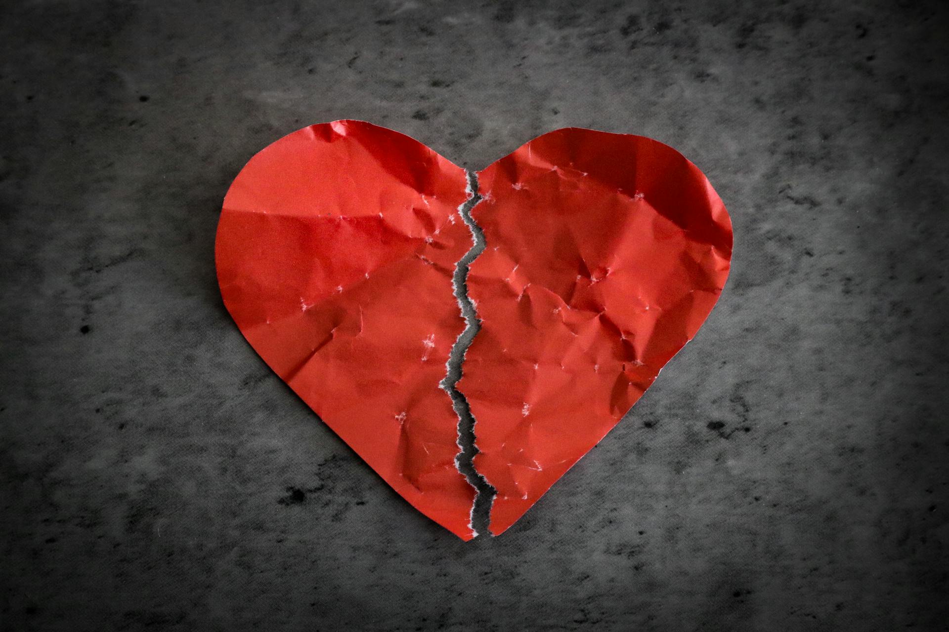 Un corazón de papel rojo partido por la mitad | Fuente: Pexels