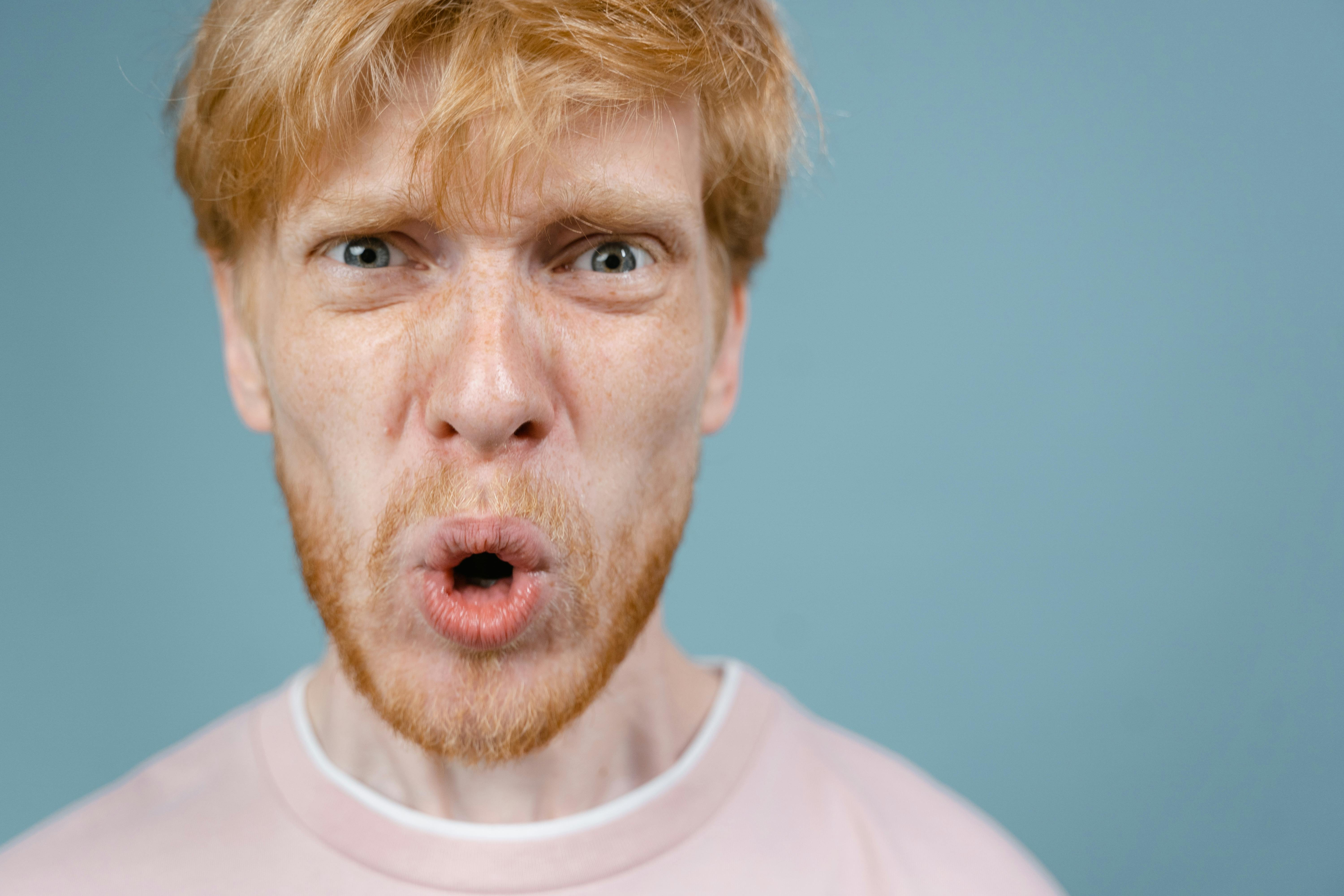 Un hombre enfadado con una camiseta rosa | Fuente: Pexels
