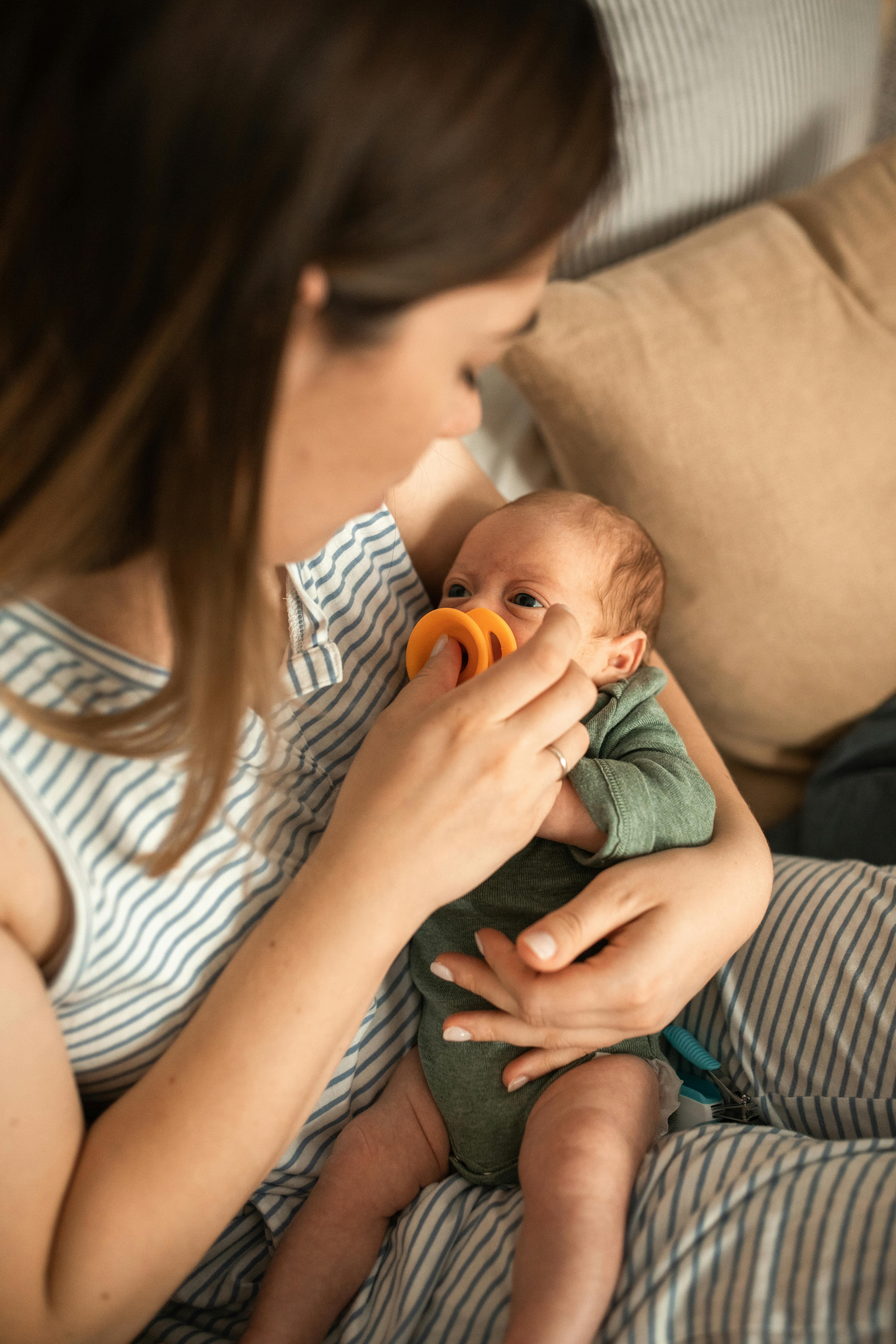 Una mamá llevando a un bebé | Fuente: Pexels