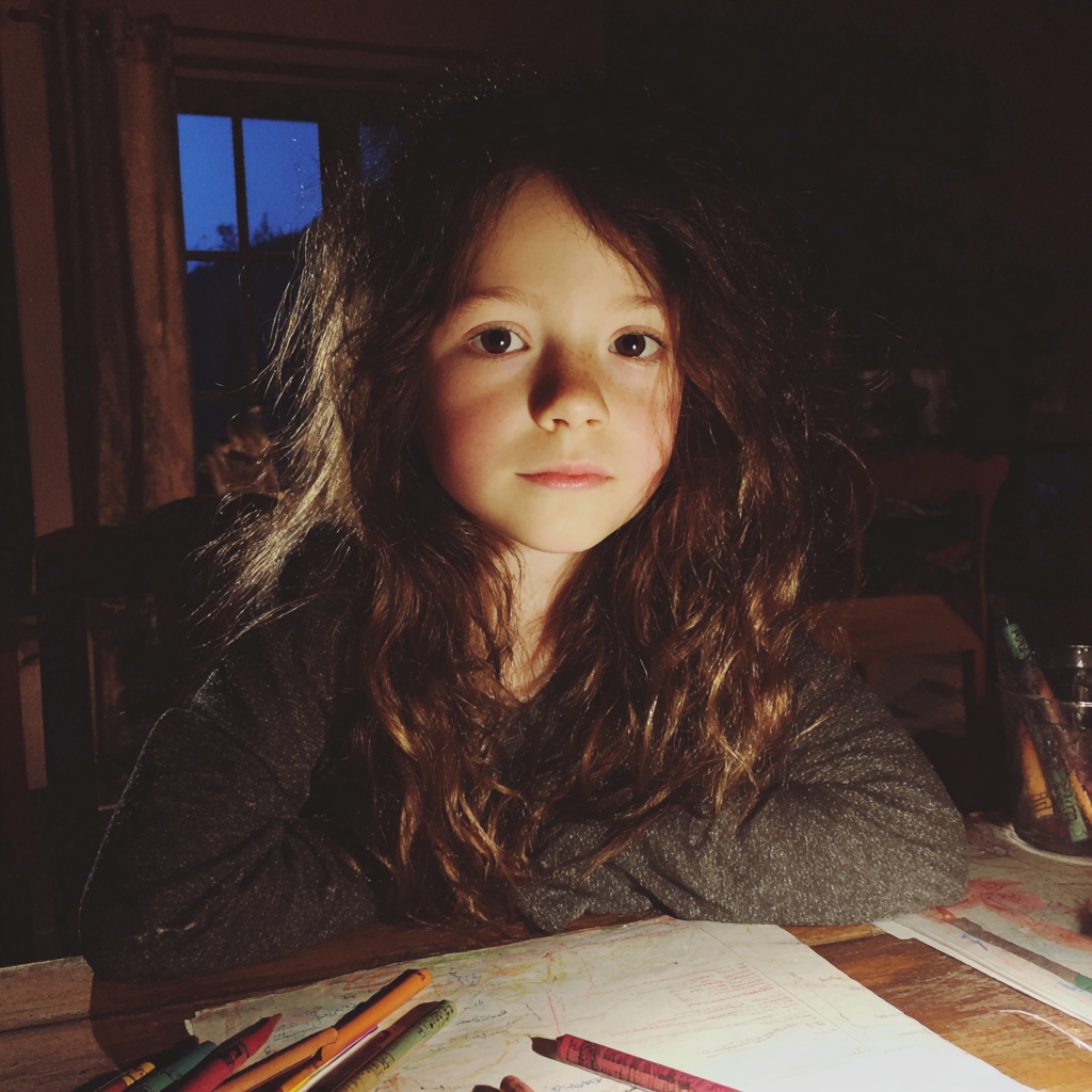 Una niña sentada a la mesa del comedor | Fuente: Midjourney