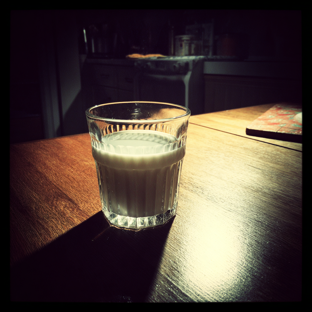 Un vaso de leche sobre una mesa | Fuente: Midjourney