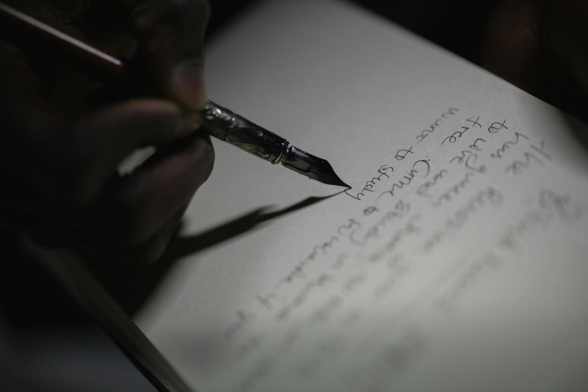Una persona escribiendo en un papel | Fuente: Pexels