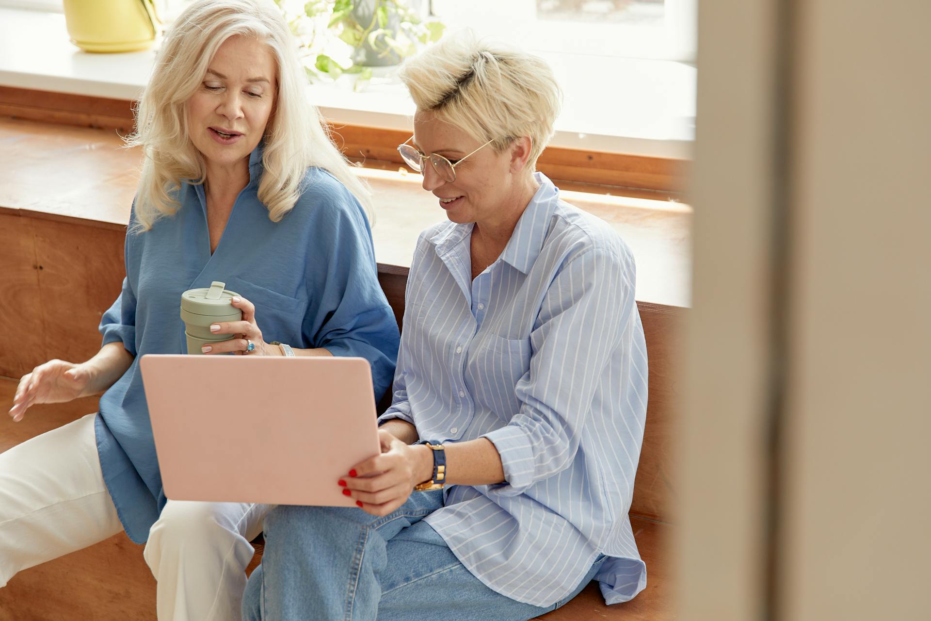 Dos mujeres mayores hablando mientras miran la pantalla de un portátil | Fuente: Pexels