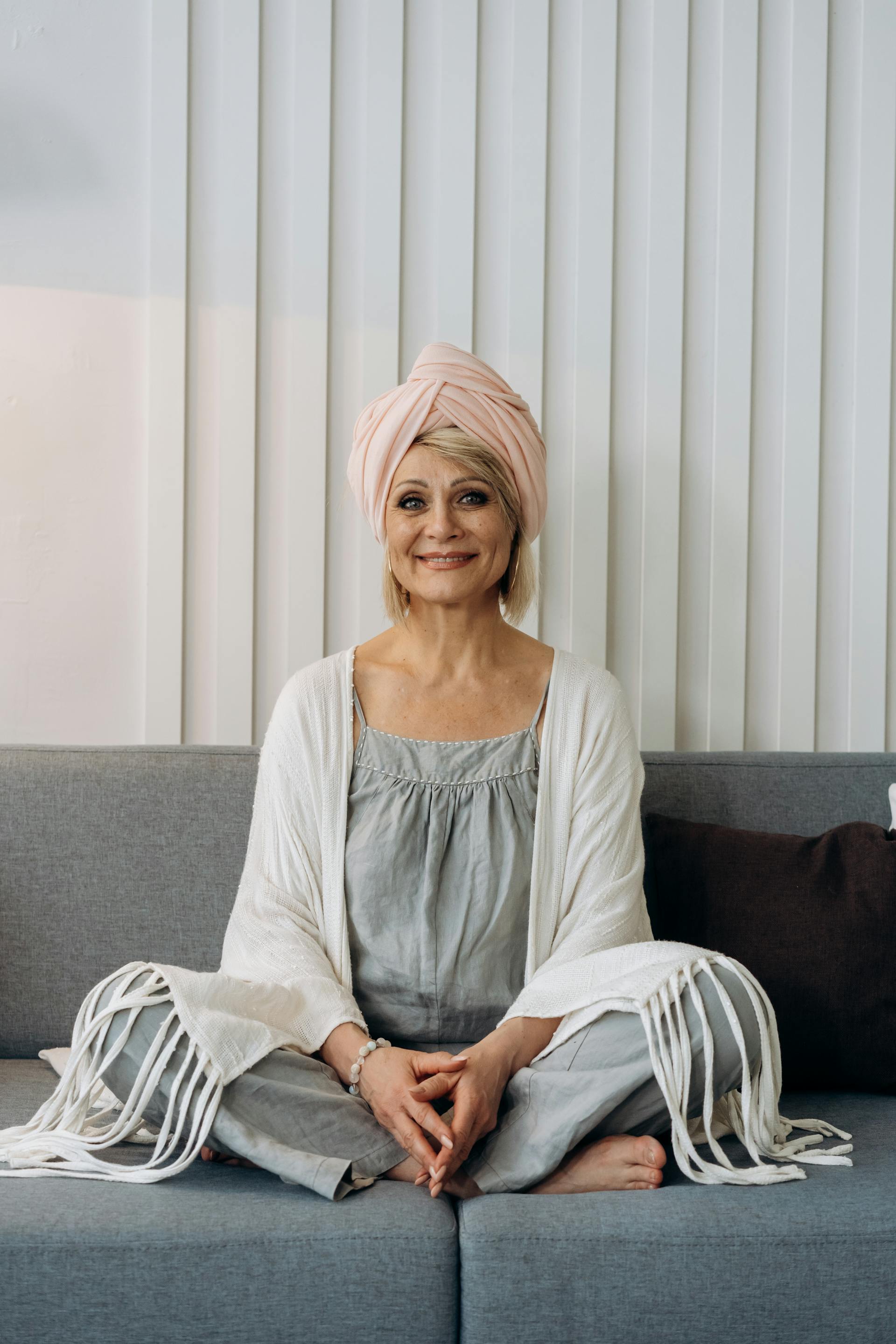 Una mujer sonriente sentada en un sofá | Fuente: Pexels