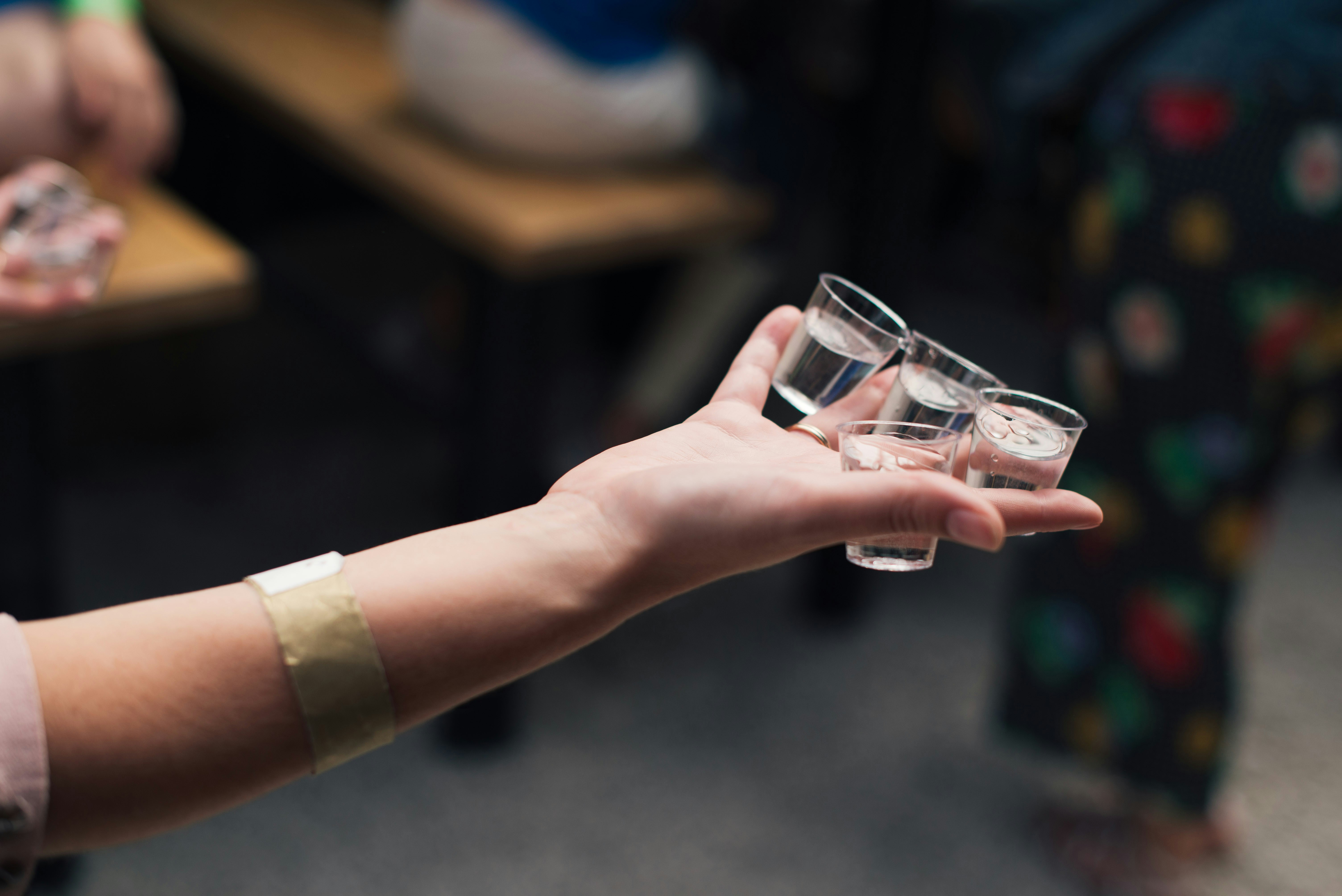 Una persona sosteniendo vasos de chupito | Fuente: Unsplash