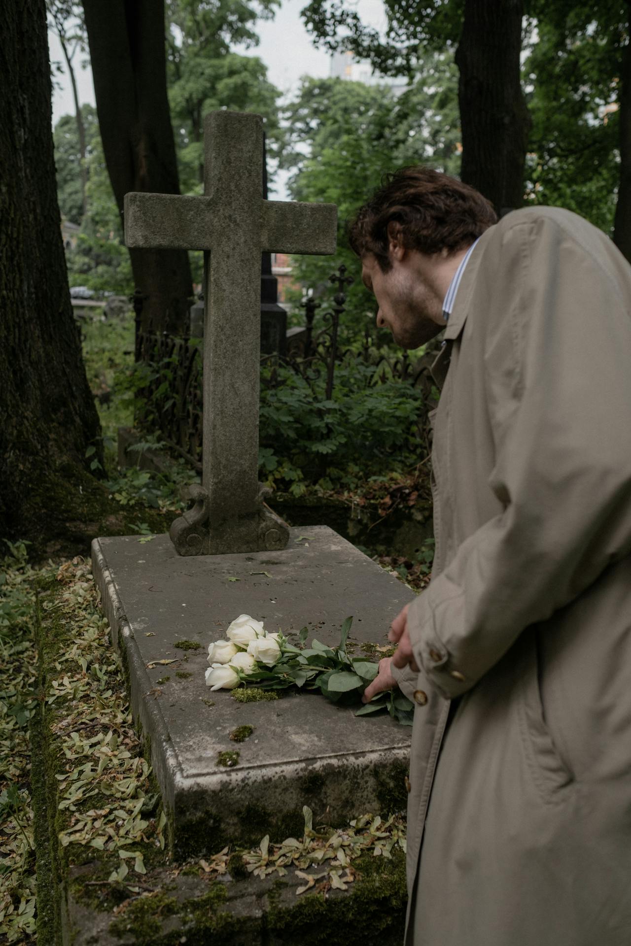 Un hombre colocando flores en una tumba | Fuente: Pexels