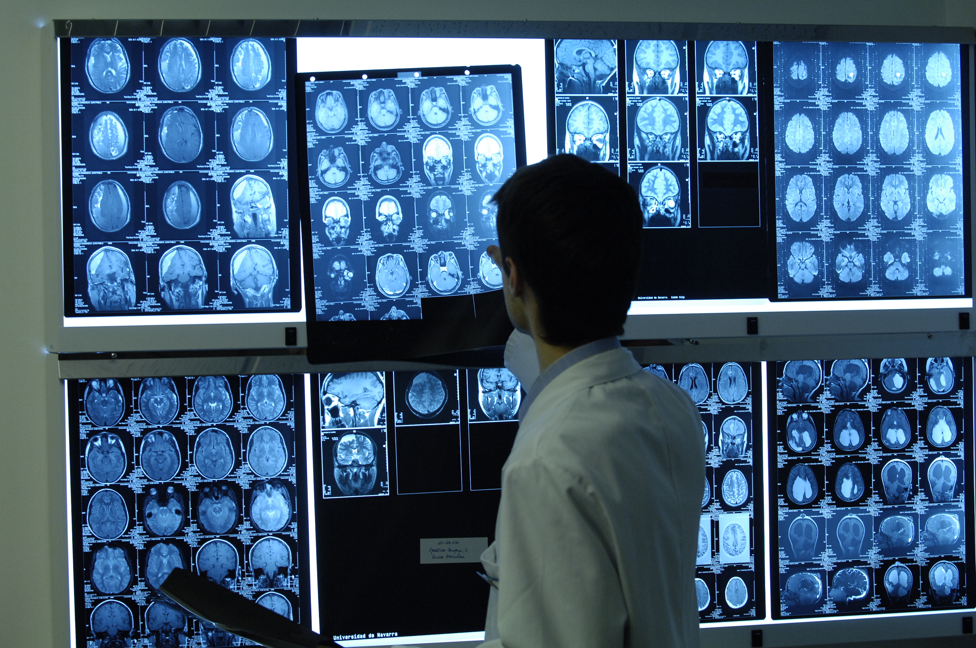 Un profesional médico revisa varias imágenes radiológicas. | Fuente: Wikimedia Commons