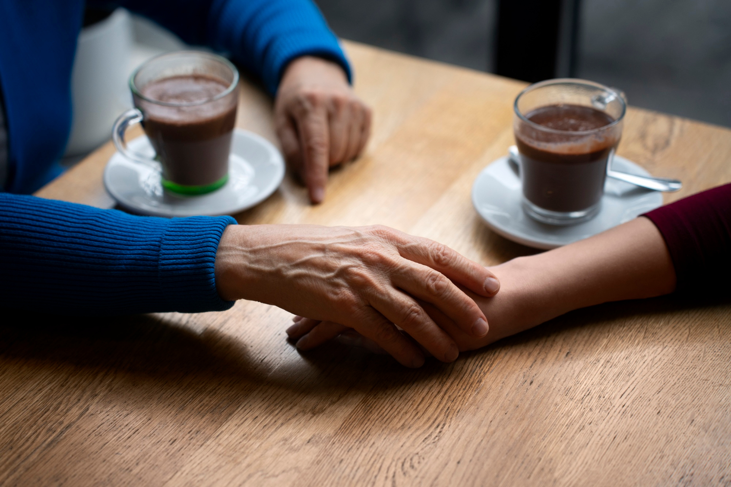 Una mujer mayor cogiendo de la mano a una joven | Fuente: Freepik