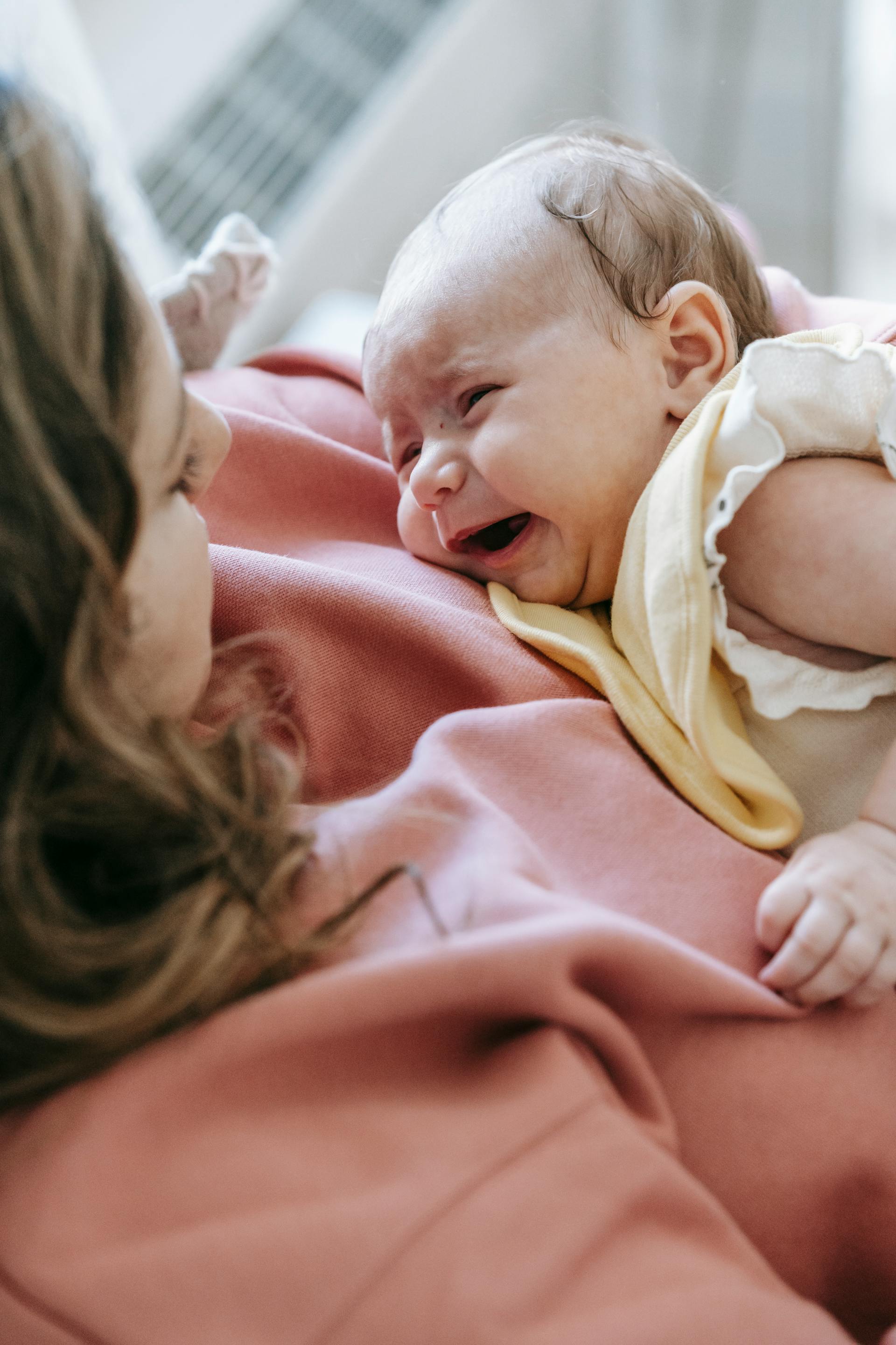 Una mujer con un bebé llorando en brazos | Fuente: Pexels