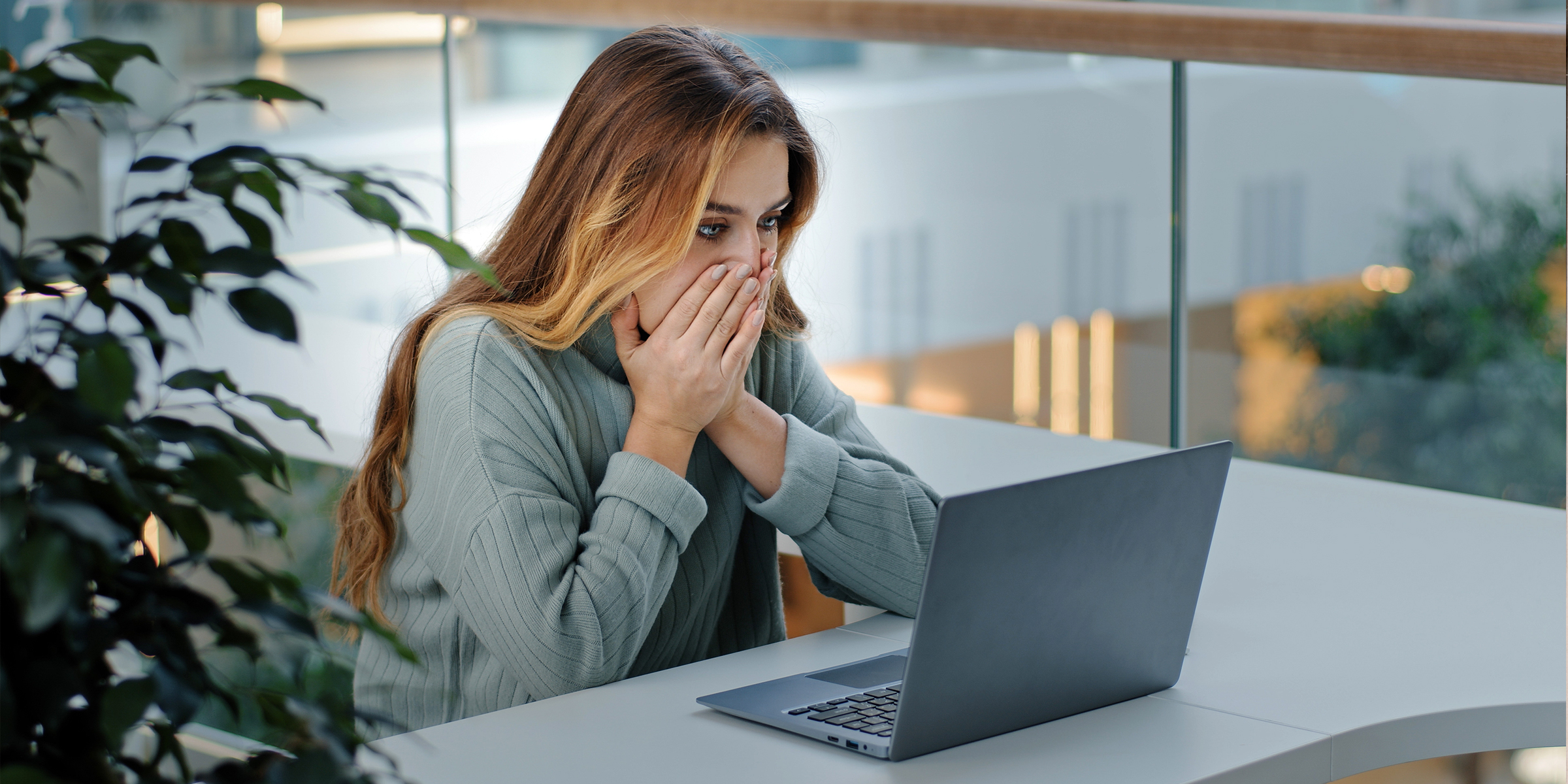 Una mujer mirando atónita su ordenador portátil | Fuente: Shutterstock