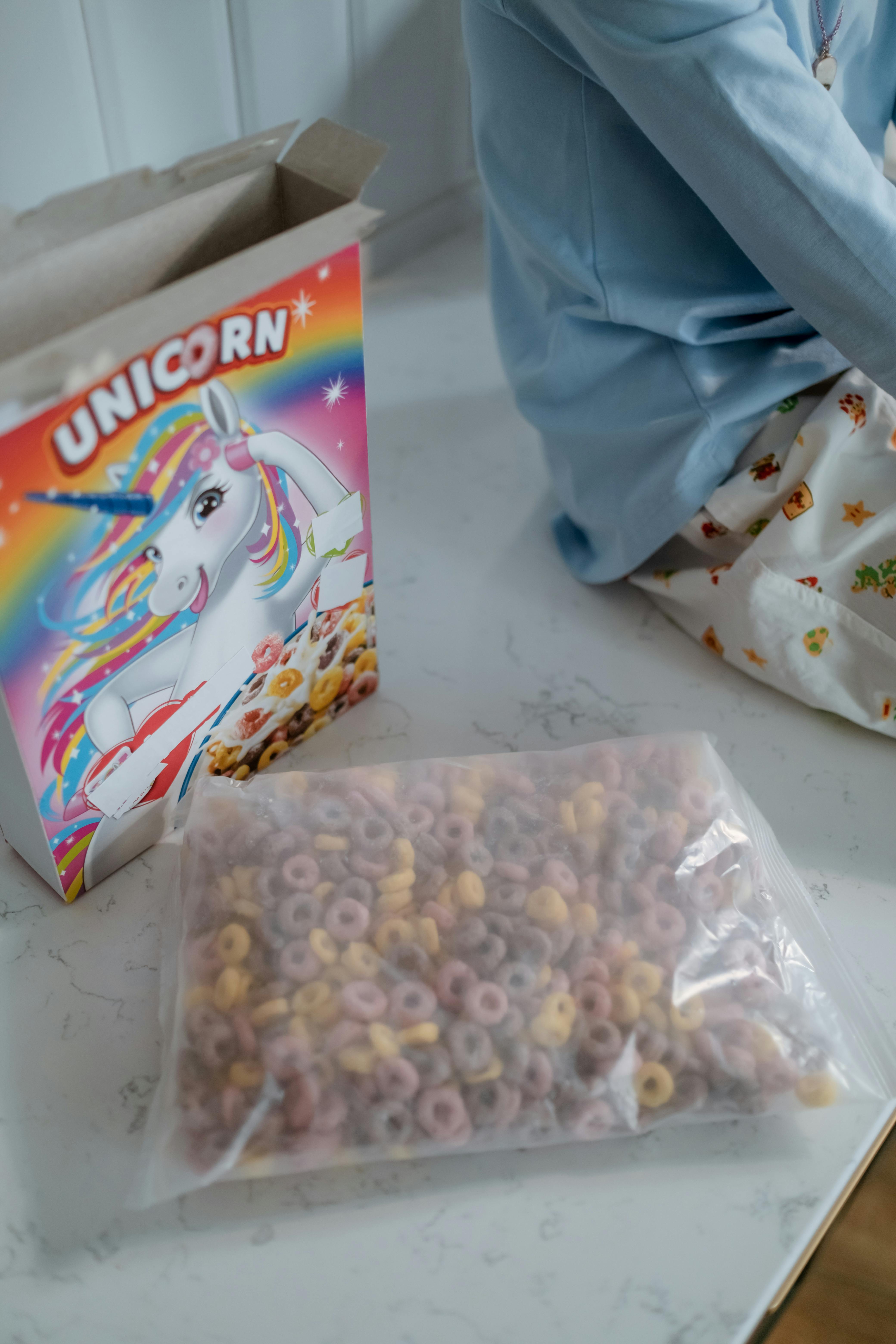 Un niña sentado en la encimera de la cocina con una bolsa de cereales | Fuente: Pexels