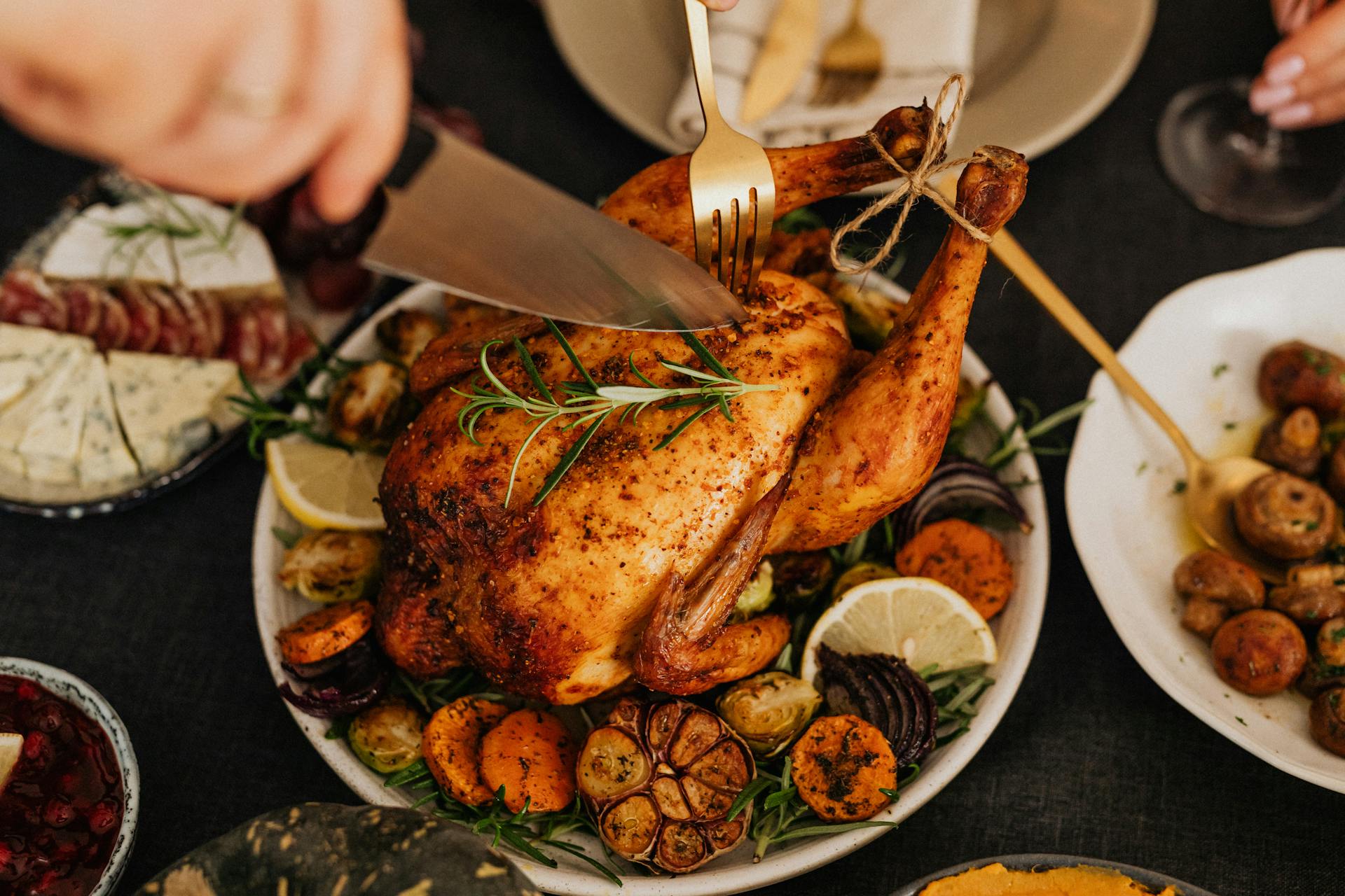 Una persona cortando pollo asado | Fuente: Pexels