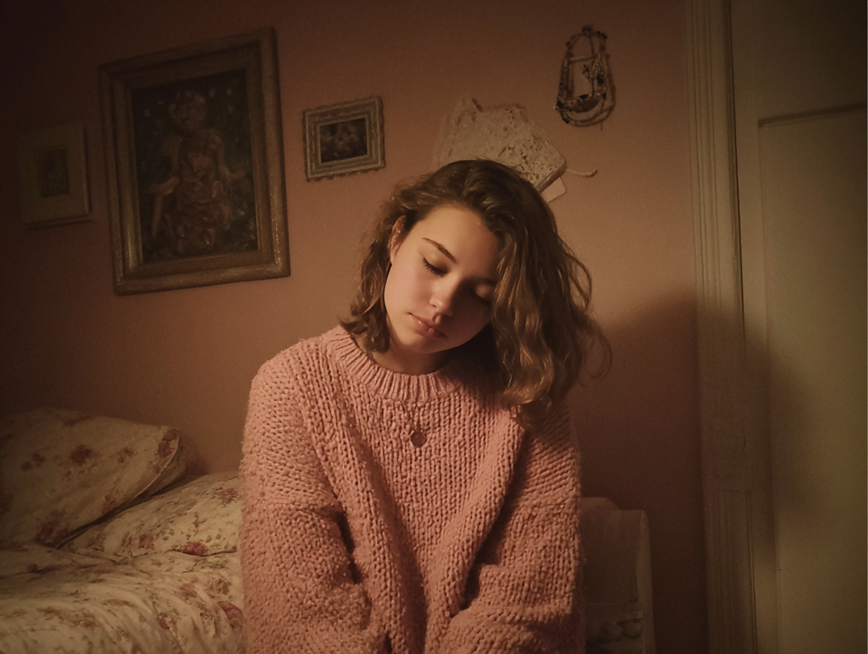 Una adolescente sentada en un dormitorio | Fuente: Midjourney