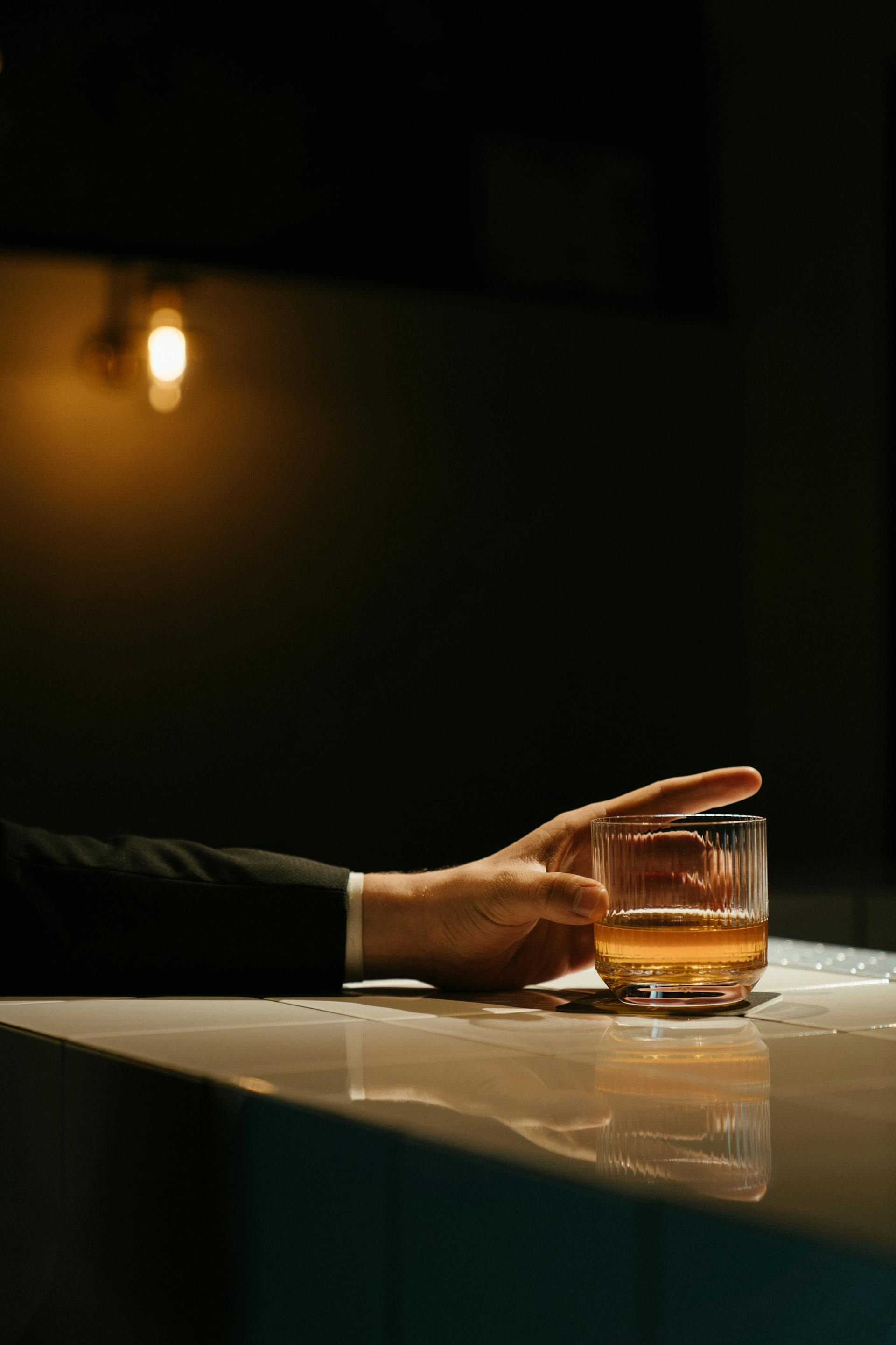 Un hombre con un vaso de whisky en la mano | Fuente: Pexels