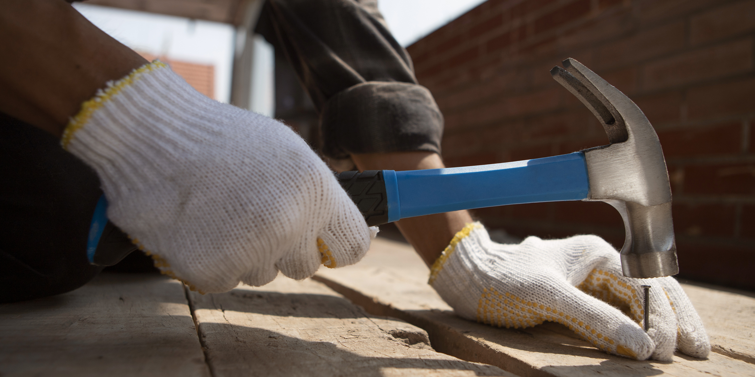 Alguien clavando un clavo en una tabla de madera | Fuente: Freepik