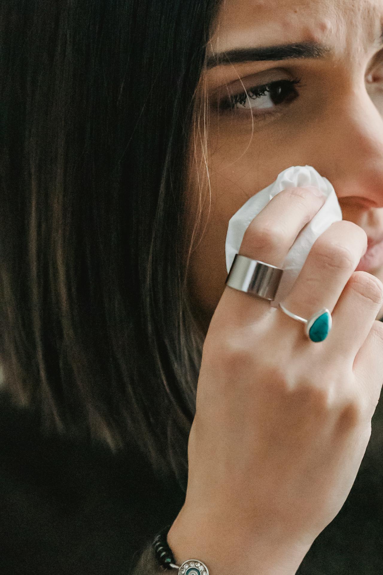 Una mujer triste limpiándose la cara con papel de seda | Fuente: Pexels