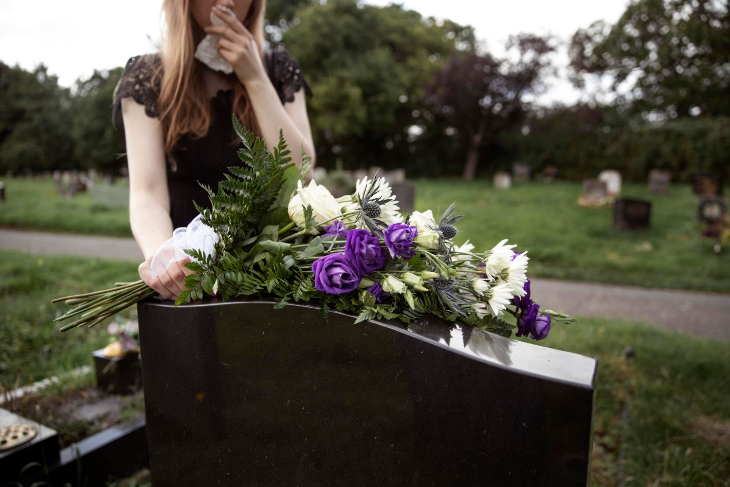 Una mujer de luto poniendo flores en una tumba | Fuente: Freepik