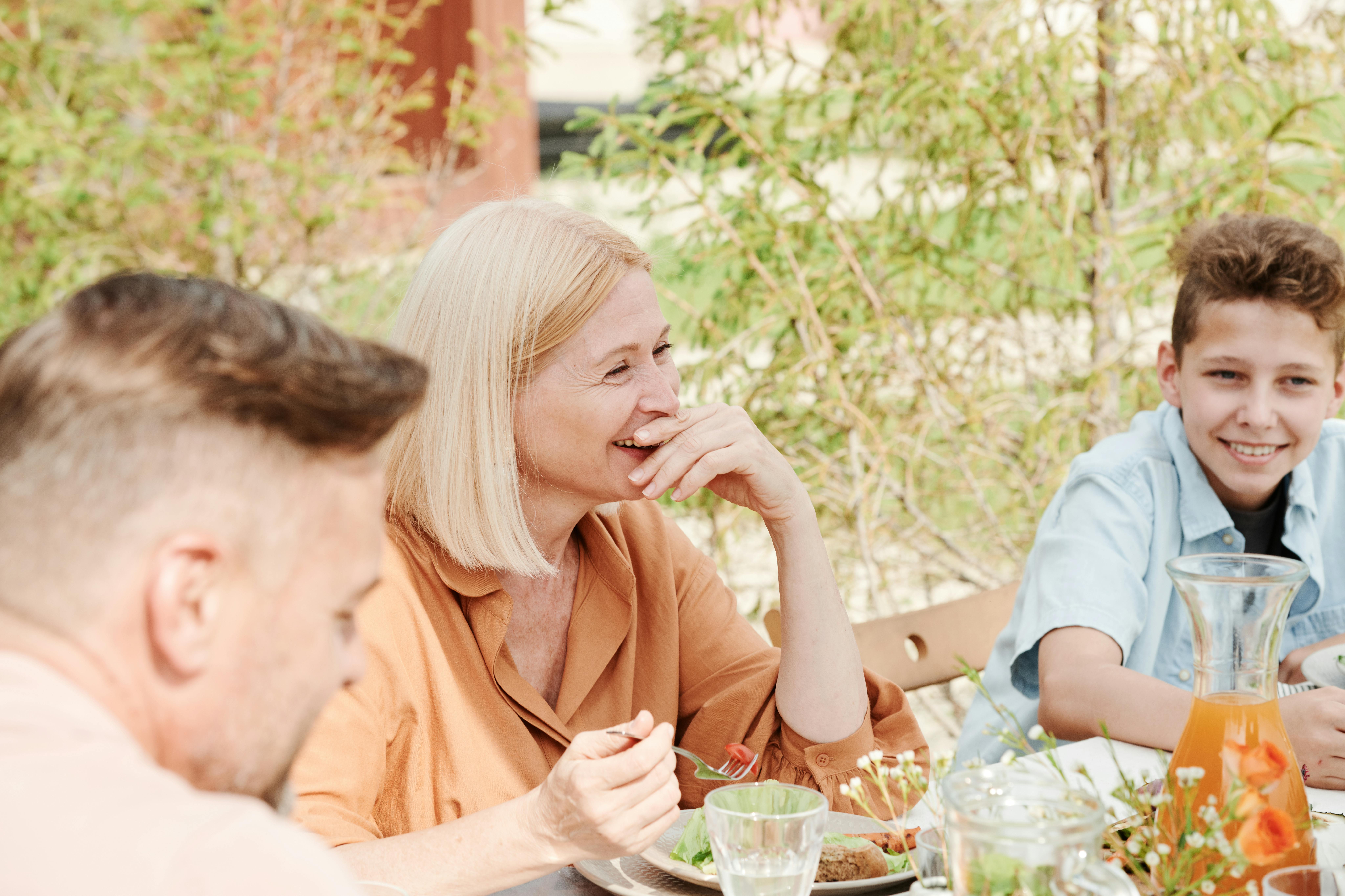 Una familia comiendo junta al aire libre | Fuente: Pexels