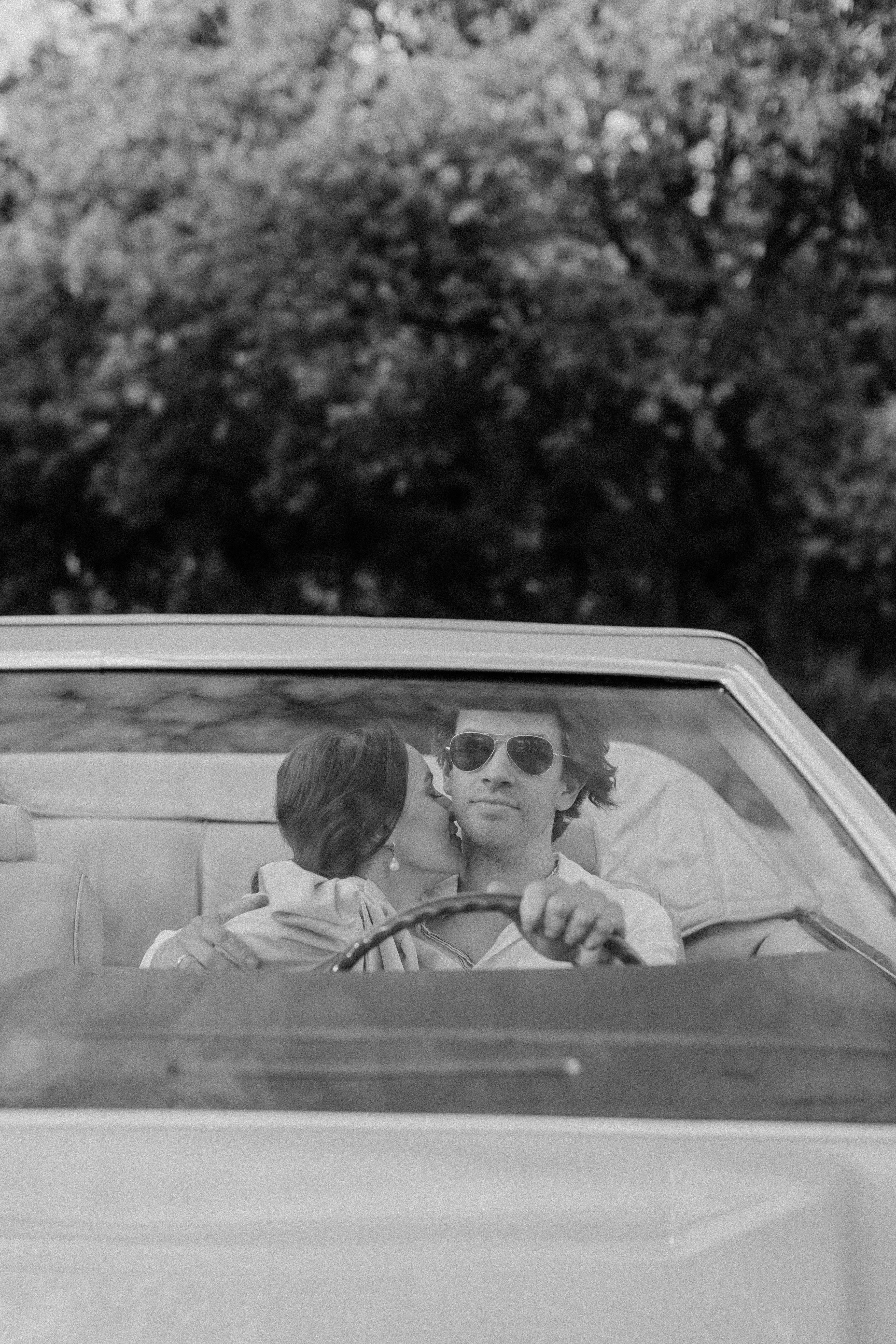 Un hombre conduciendo mientras una mujer lo besa | Fuente: Pexels