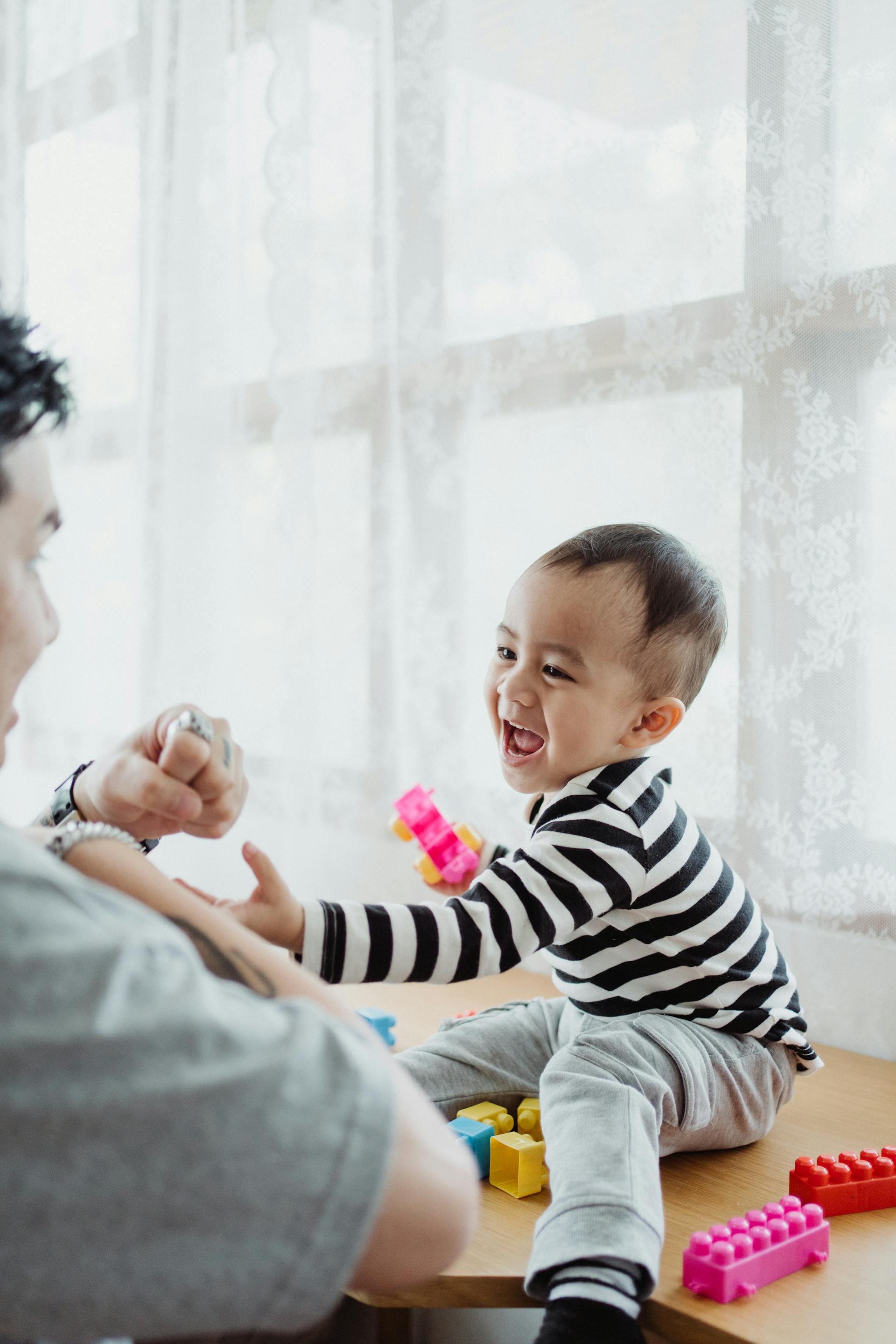 Un niño riendo mientras juega con su papá | Fuente: Pexels
