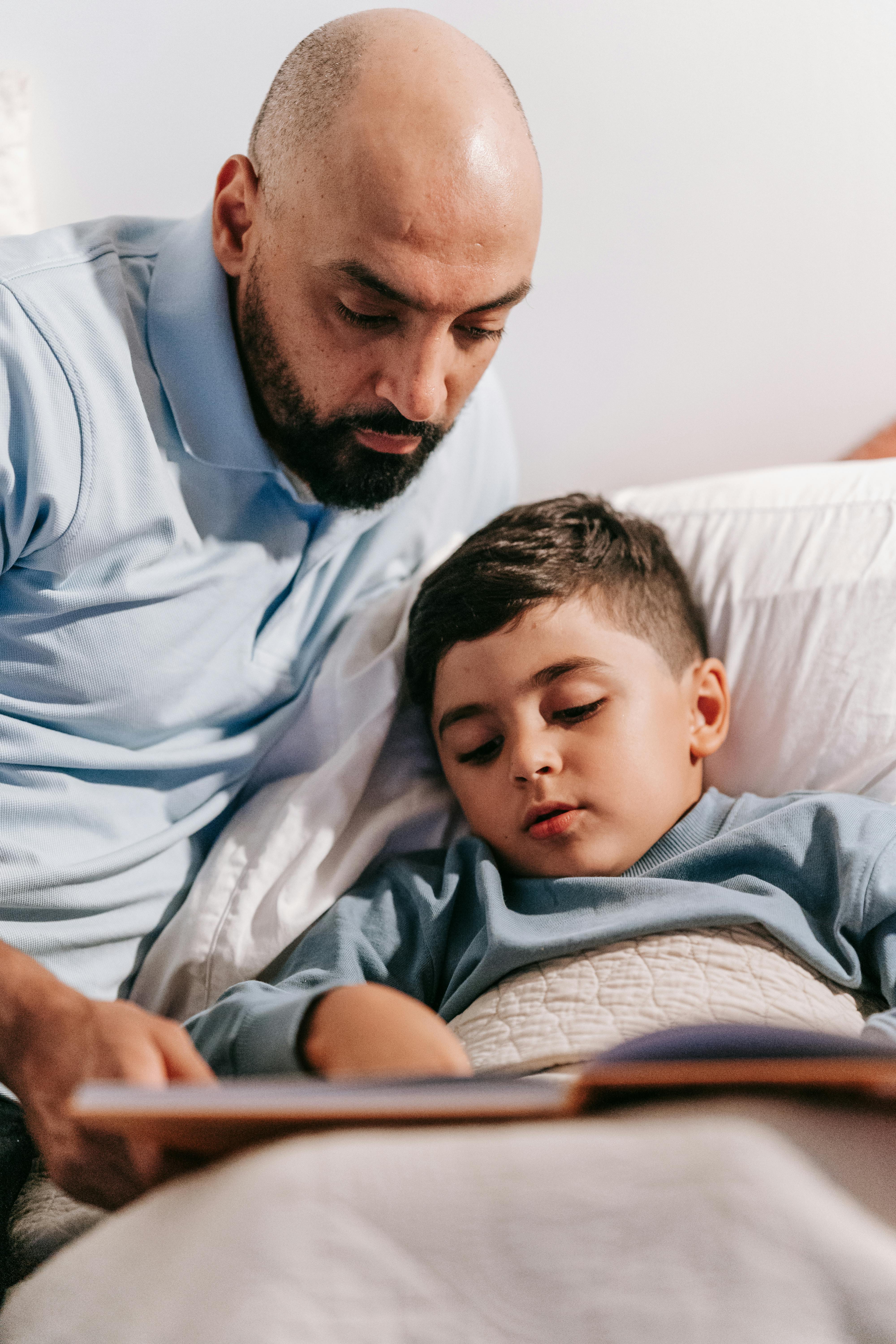 Un hombre leyendo un cuento a su hijo | Fuente: Pexels