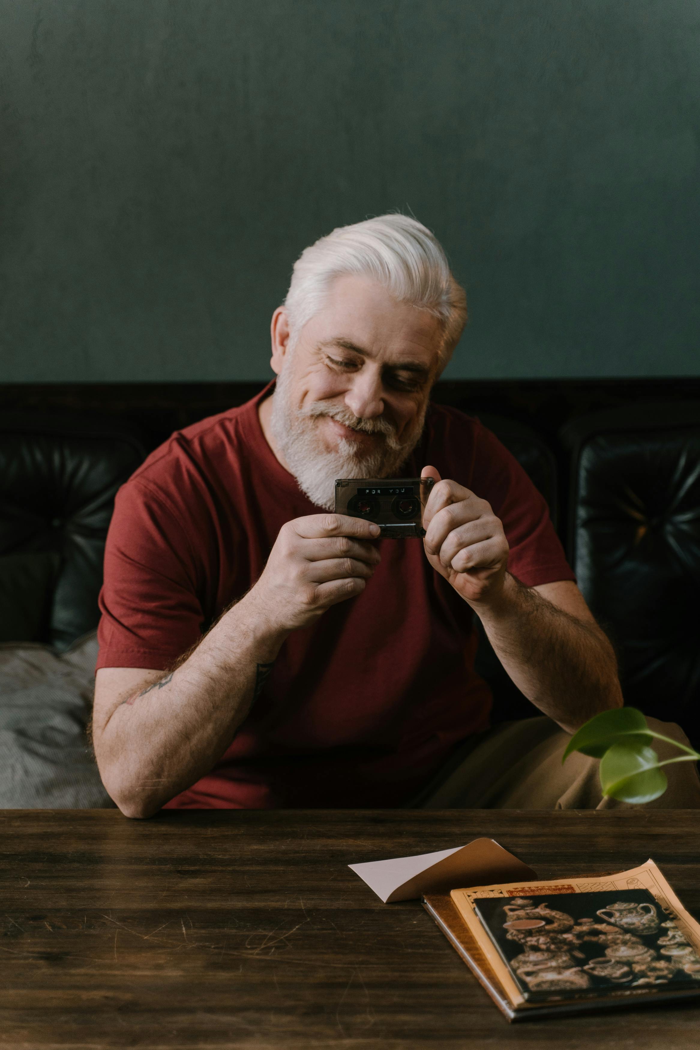 Un hombre mayor sonriente sentado a una mesa | Fuente: Pexels