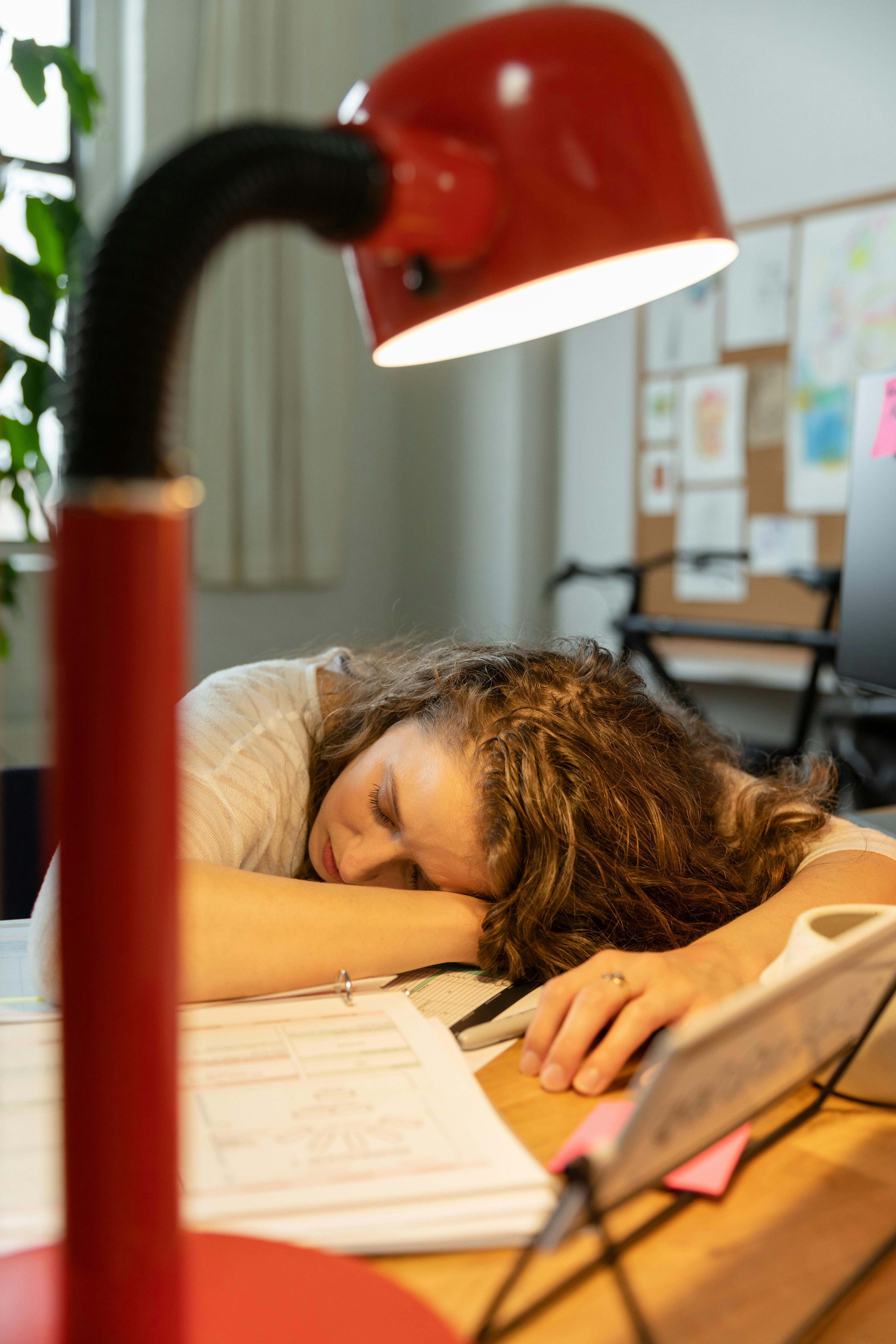 Una mujer durmiendo sobre un escritorio | Fuente: Pexels