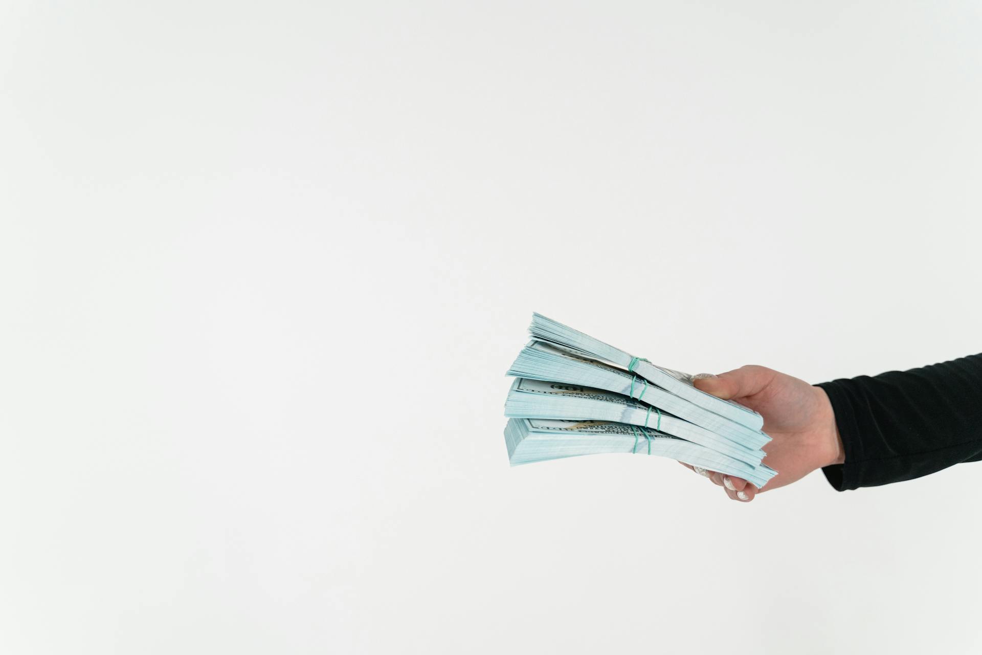 Primer plano de una persona sujetando fajos de dinero | Fuente: Pexels