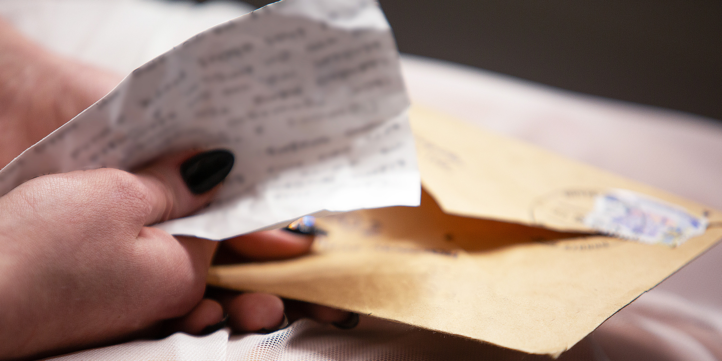 Una persona sostiene un sobre y una carta | Fuente: Shutterstock