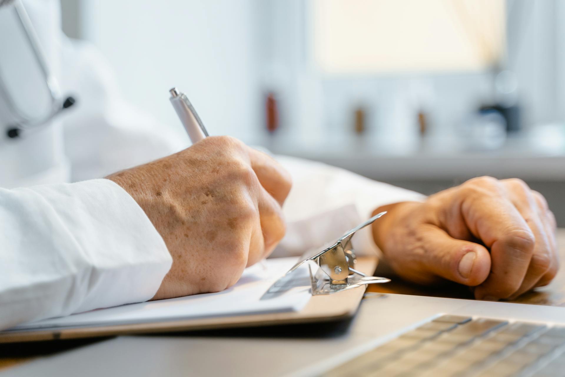 Un médico escribiendo en un papel | Fuente: Pexels