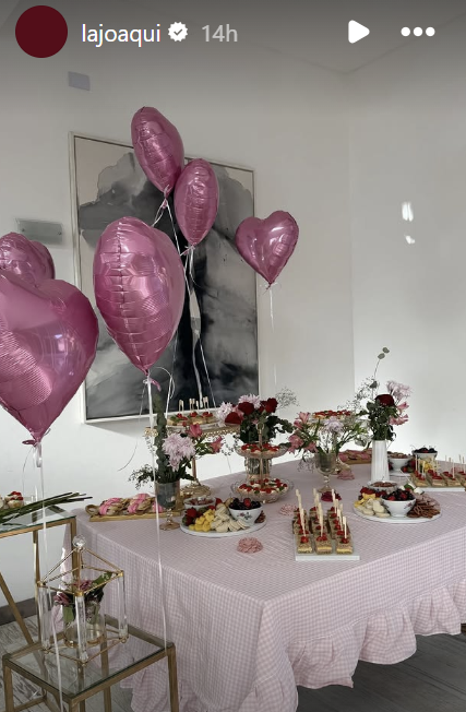 Decoraciones de flores y globos sobre una mesa llena de comida en el cumpleaños de Eva | Fuente: Instagram Stories/lajoaqui
