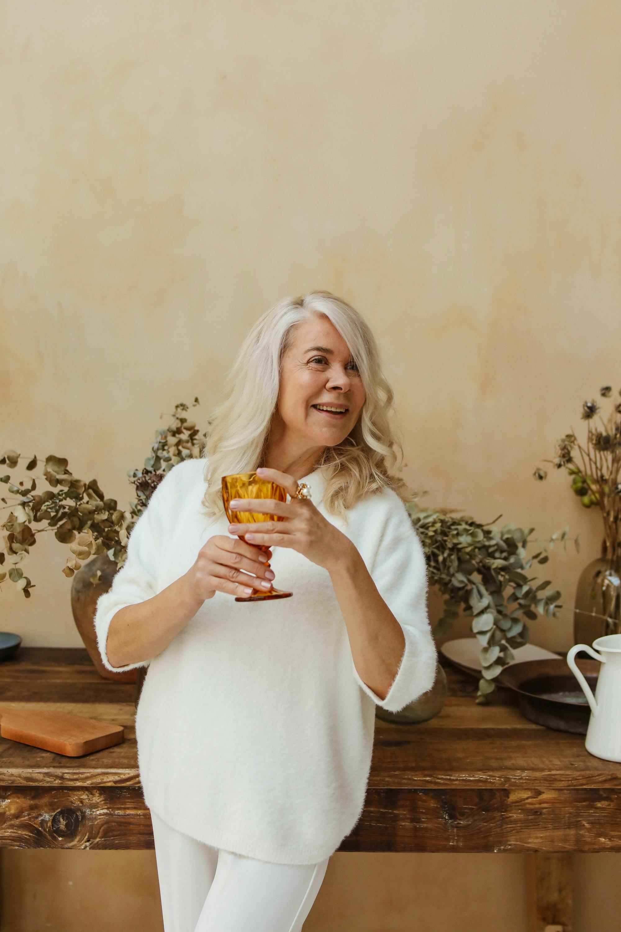 Una mujer mayor con un vaso en la mano | Fuente: Pexels
