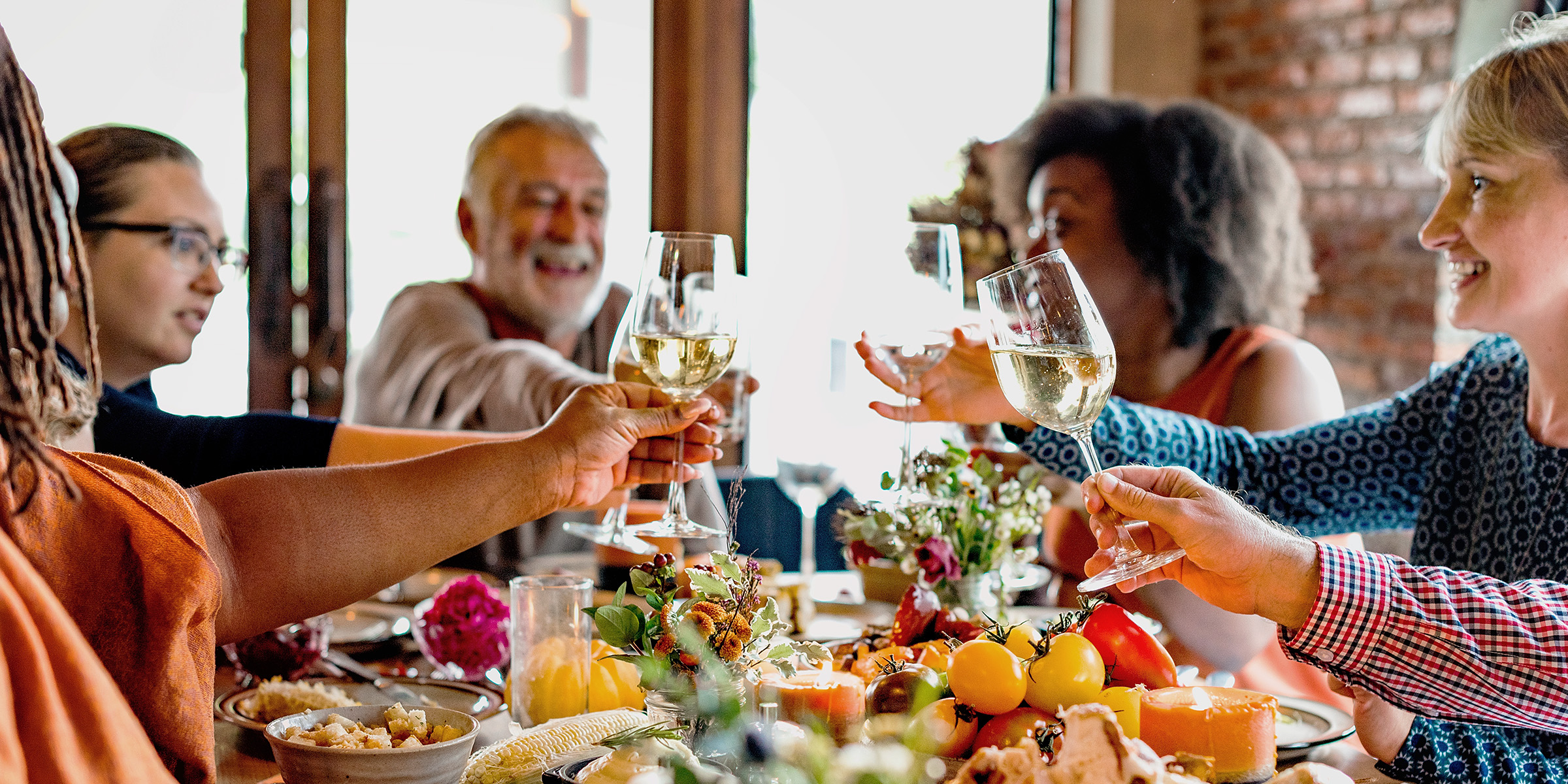 Una familia brindando mientras cena | Fuente: Shutterstock