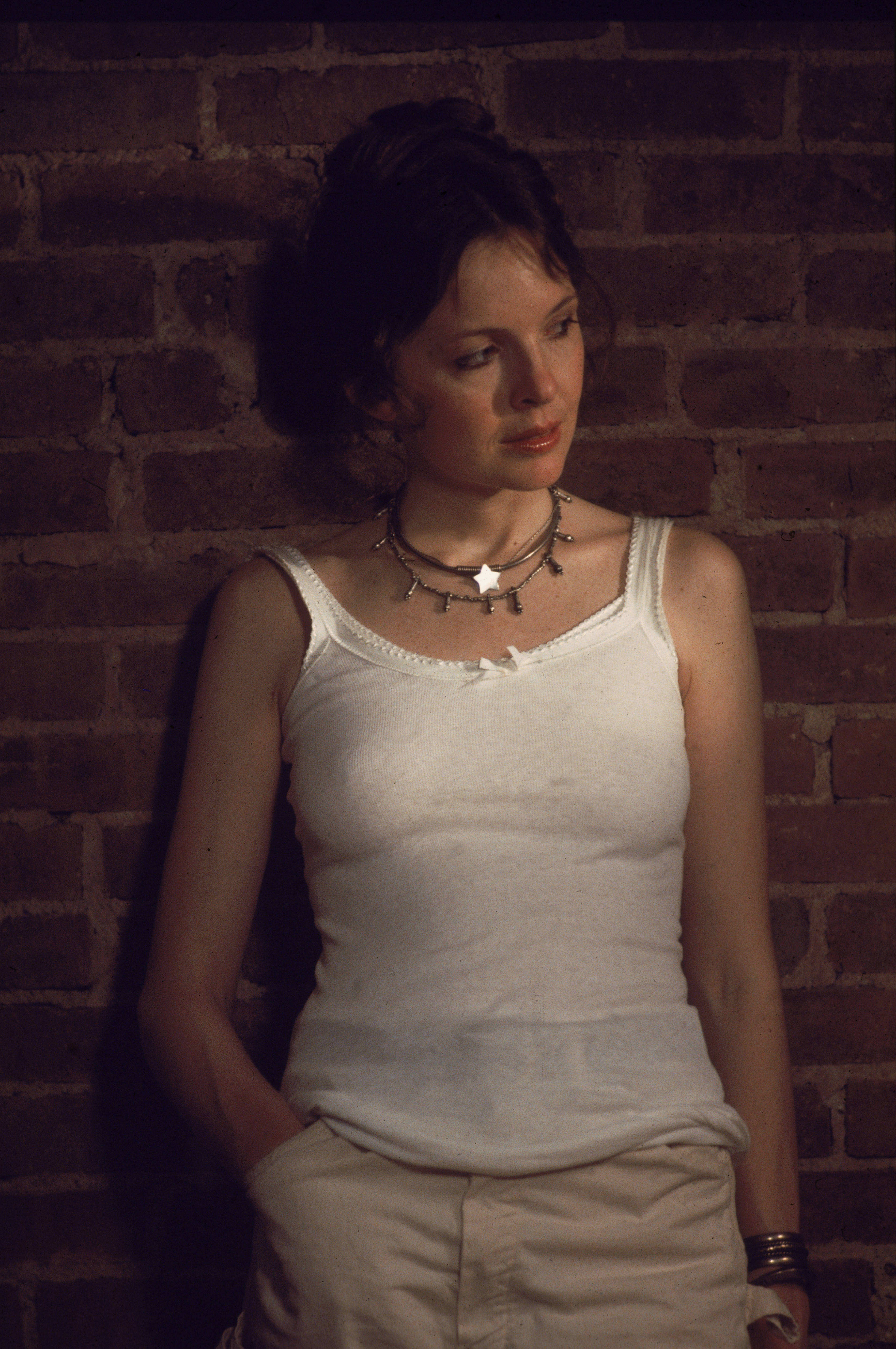 Diane Keaton viste una camiseta blanca sin mangas y se apoya contra una pared de ladrillos en una escena de "Annie Hall", dirigida por Woody Allen, en Nueva York, alrededor de 1977 | Fuente: Getty Images