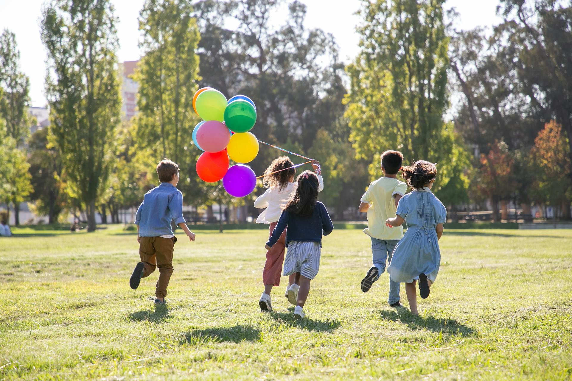 Niños jugando con globos en un parque | Fuente: Pexels